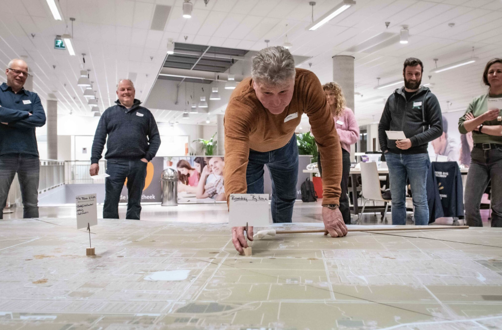 Man legt bordje op grote kaart van gemeente Haarlemmermeer