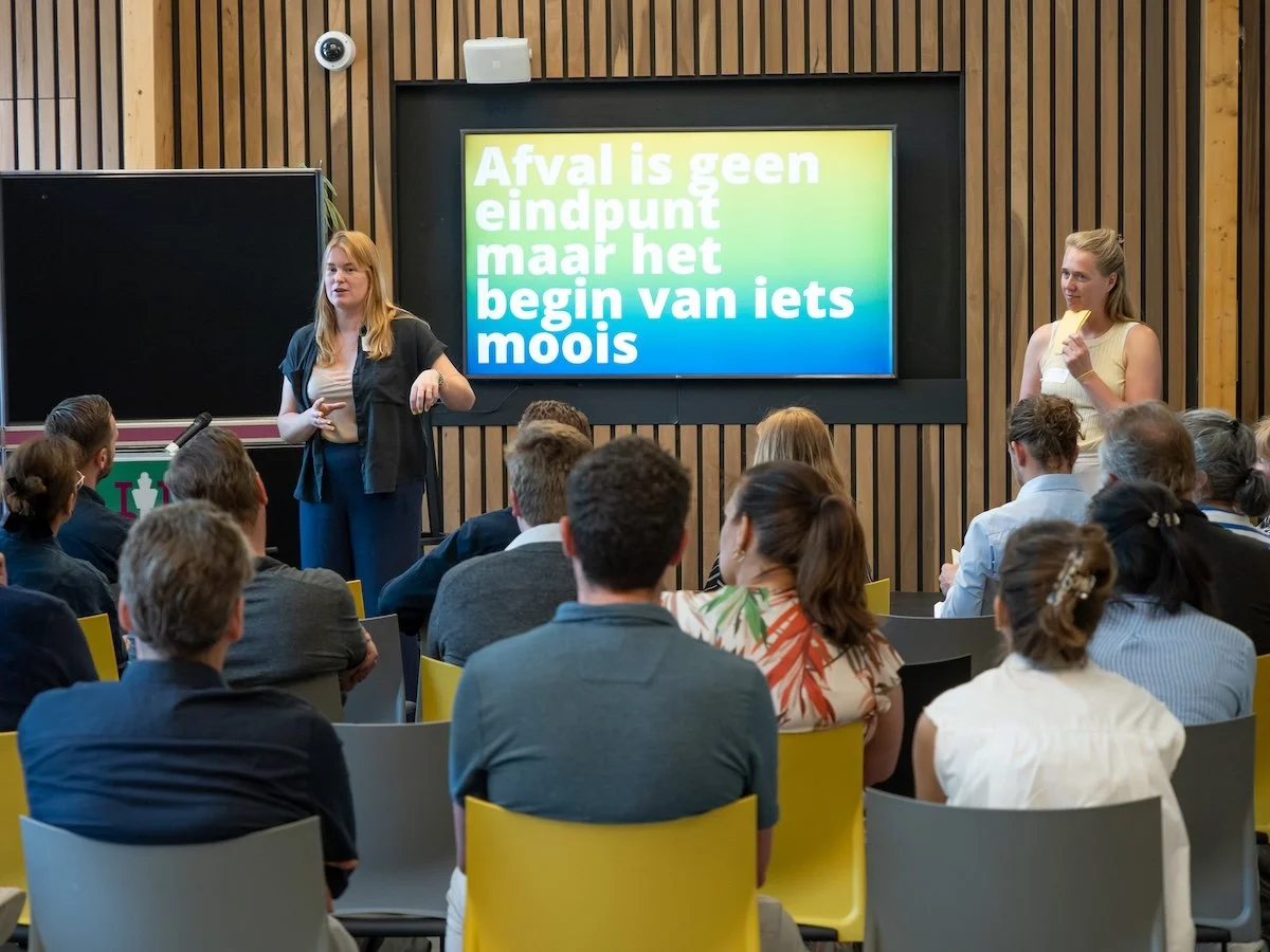 Een presentatie tijdens een zakelijk evenement over circulariteit met de tekst: afval is geen eindpunt, maar het begin van iets moois.