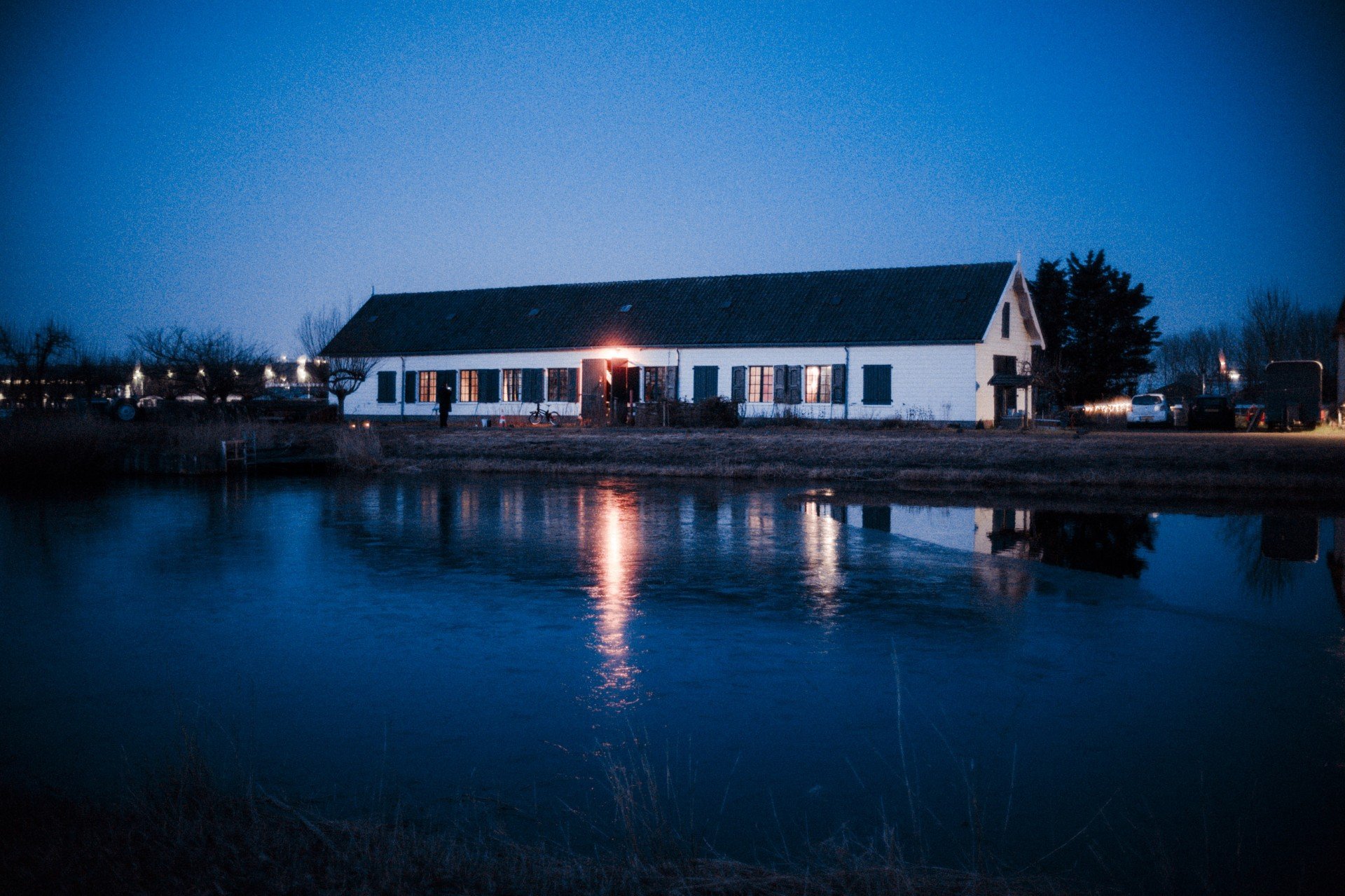 foto van fort bij aalsmeer in de avond, wit gebouw met donker dak gelegen aan het water