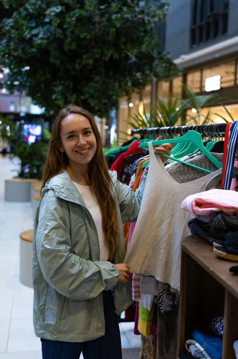 Vrouw laat tweedehandskleding zien bij een gratis kleding pop-up store in centrum Hoofddorp
