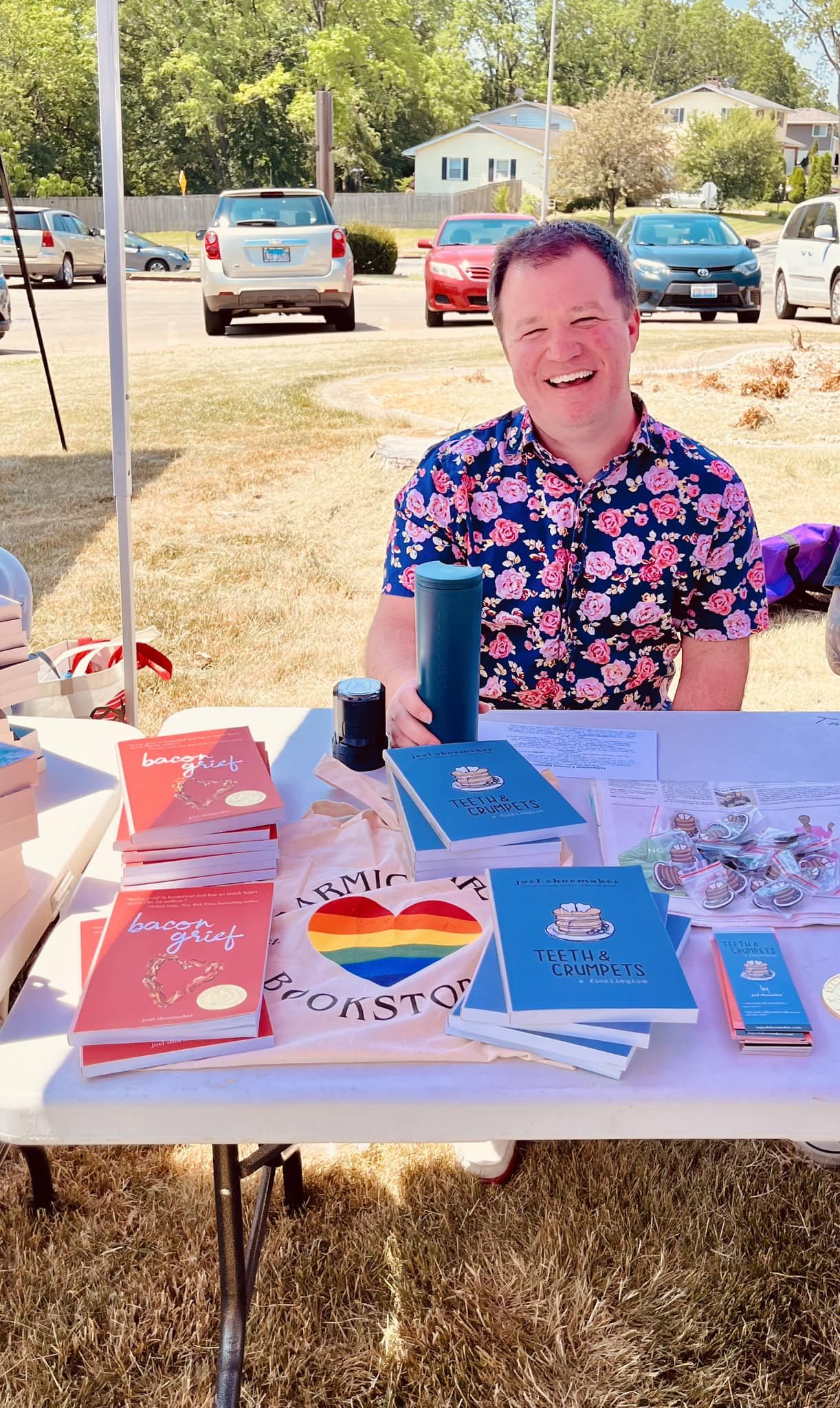 Joel in front a table of his books at a small event.