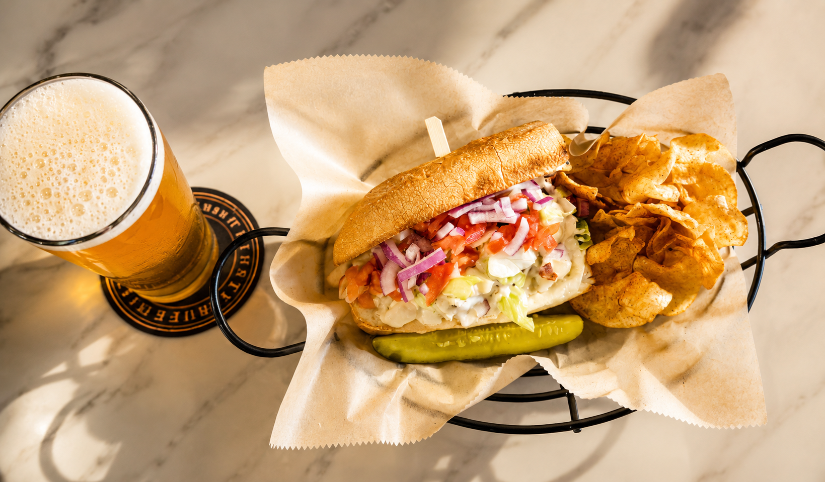 Fresh sandwich, kettle chips, pickle, and craft beer served at Thirsty Buffalo Brewing Company in Odessa, Florida