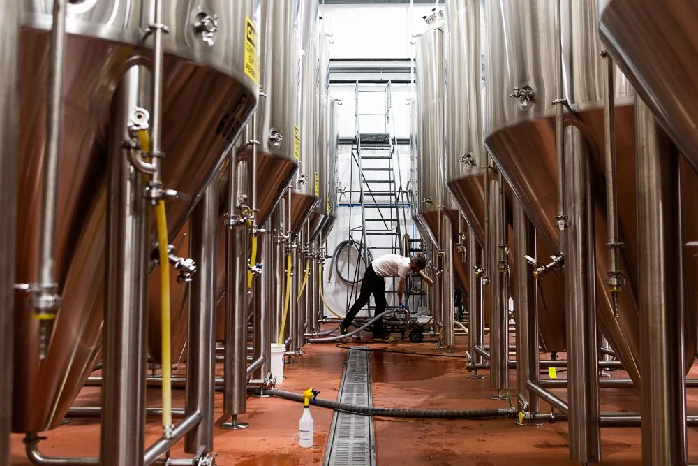 a person cleans a brewing tank
