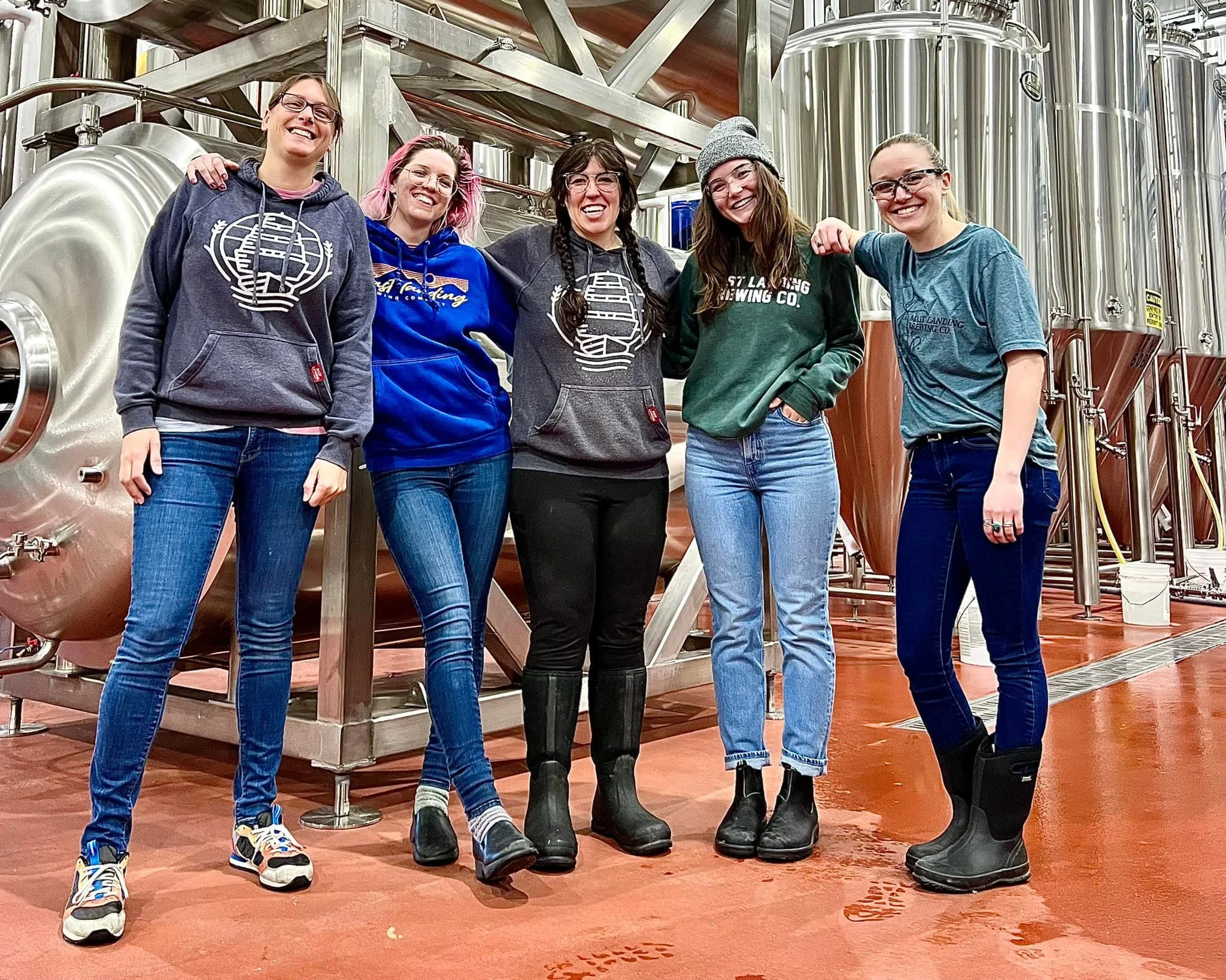 group of women stand in a brewery