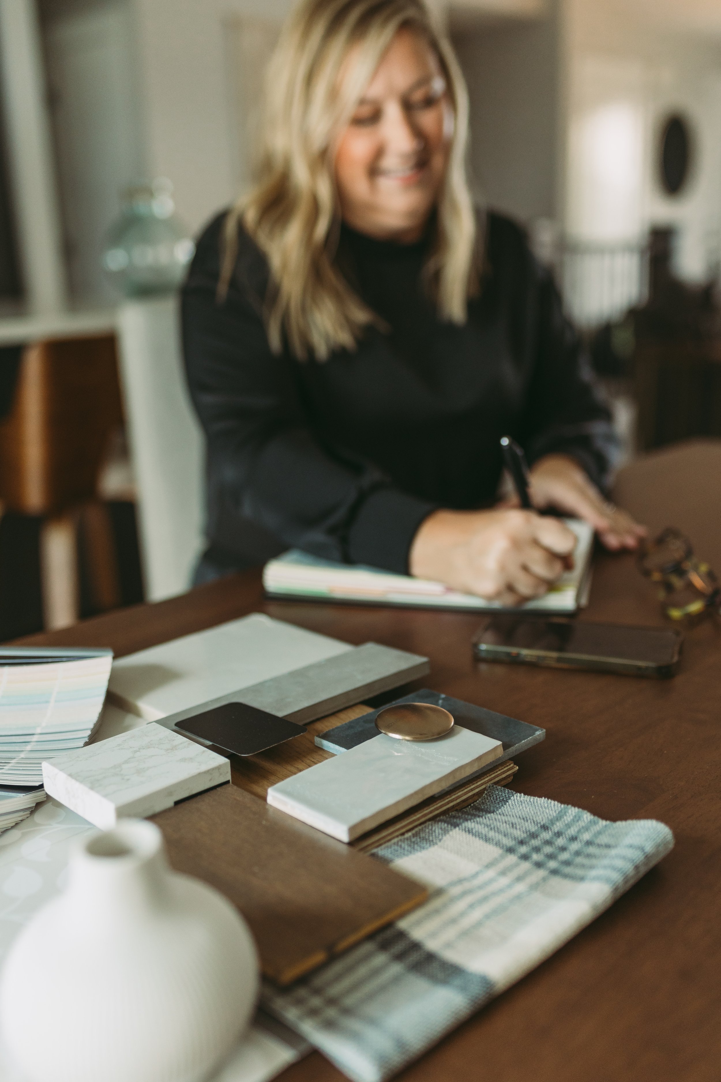 Jordan MN Interior Designer choosing and writing down the prettiest materials for an open concept kitchen and living room design