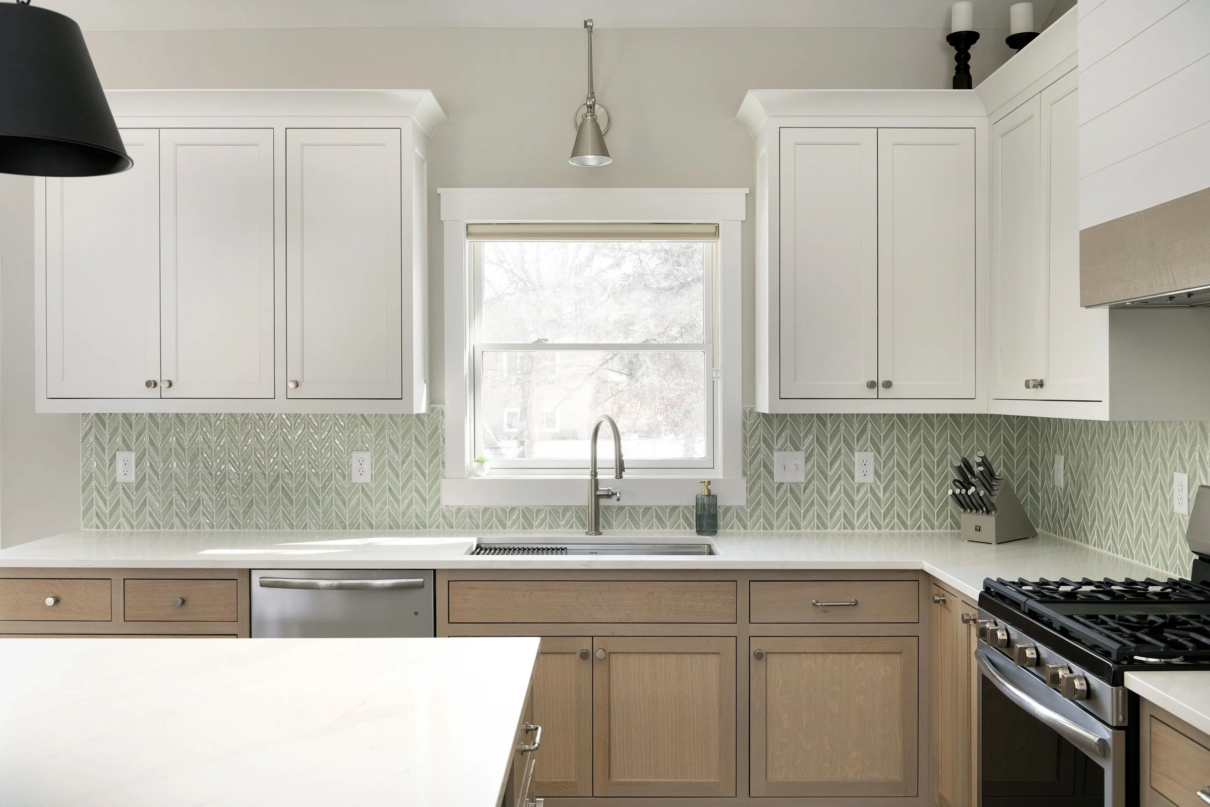 transitional kitchen featuring inset cabinetry, white quartz countertops and a chevron tile backsplash