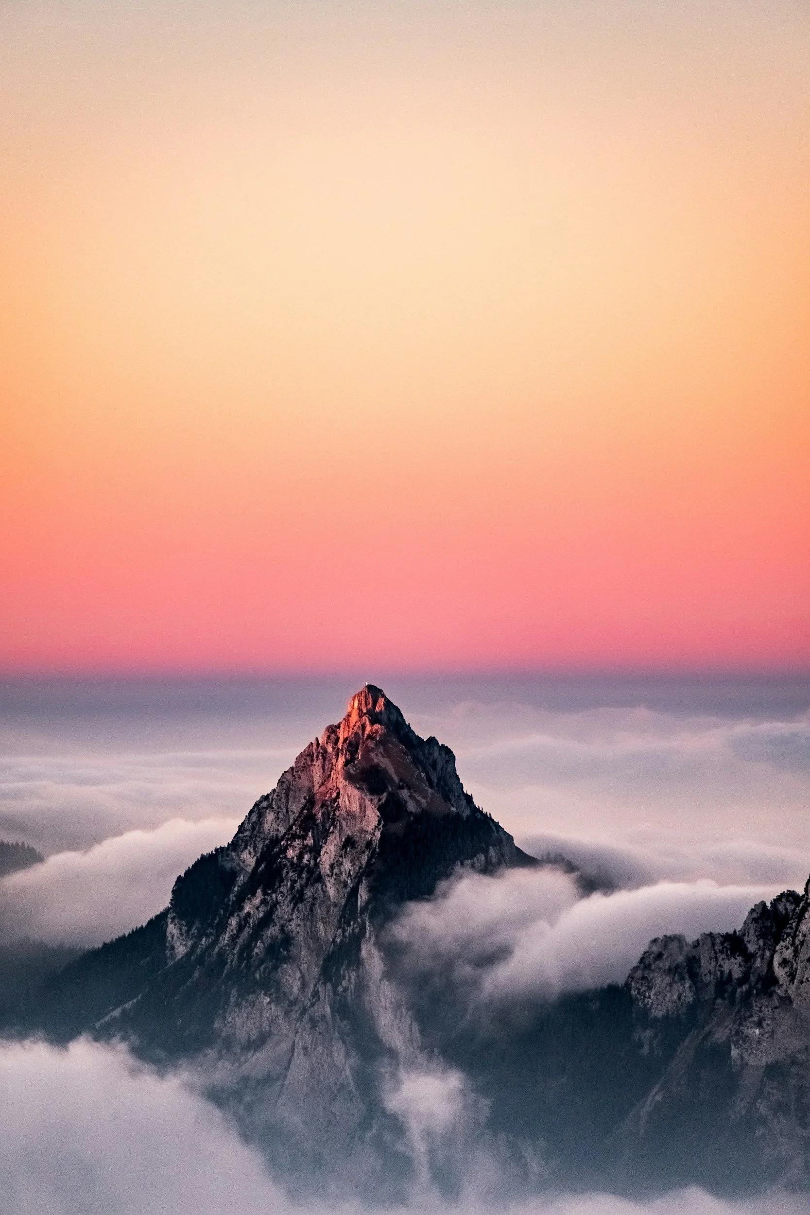 A mountain top peaking through clouds representing emotional barriers.