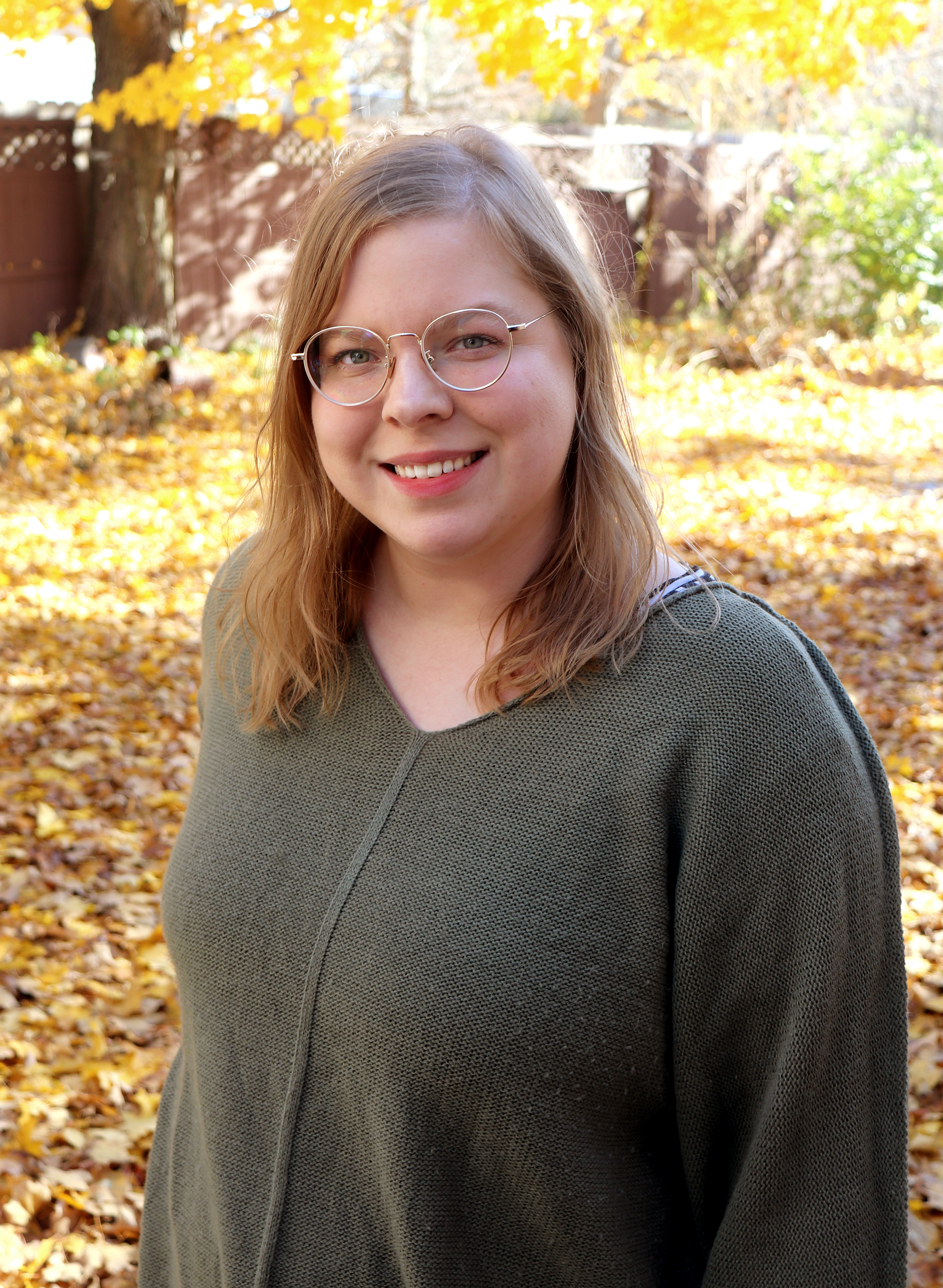 artist Arrin Kartel outside with fall leave