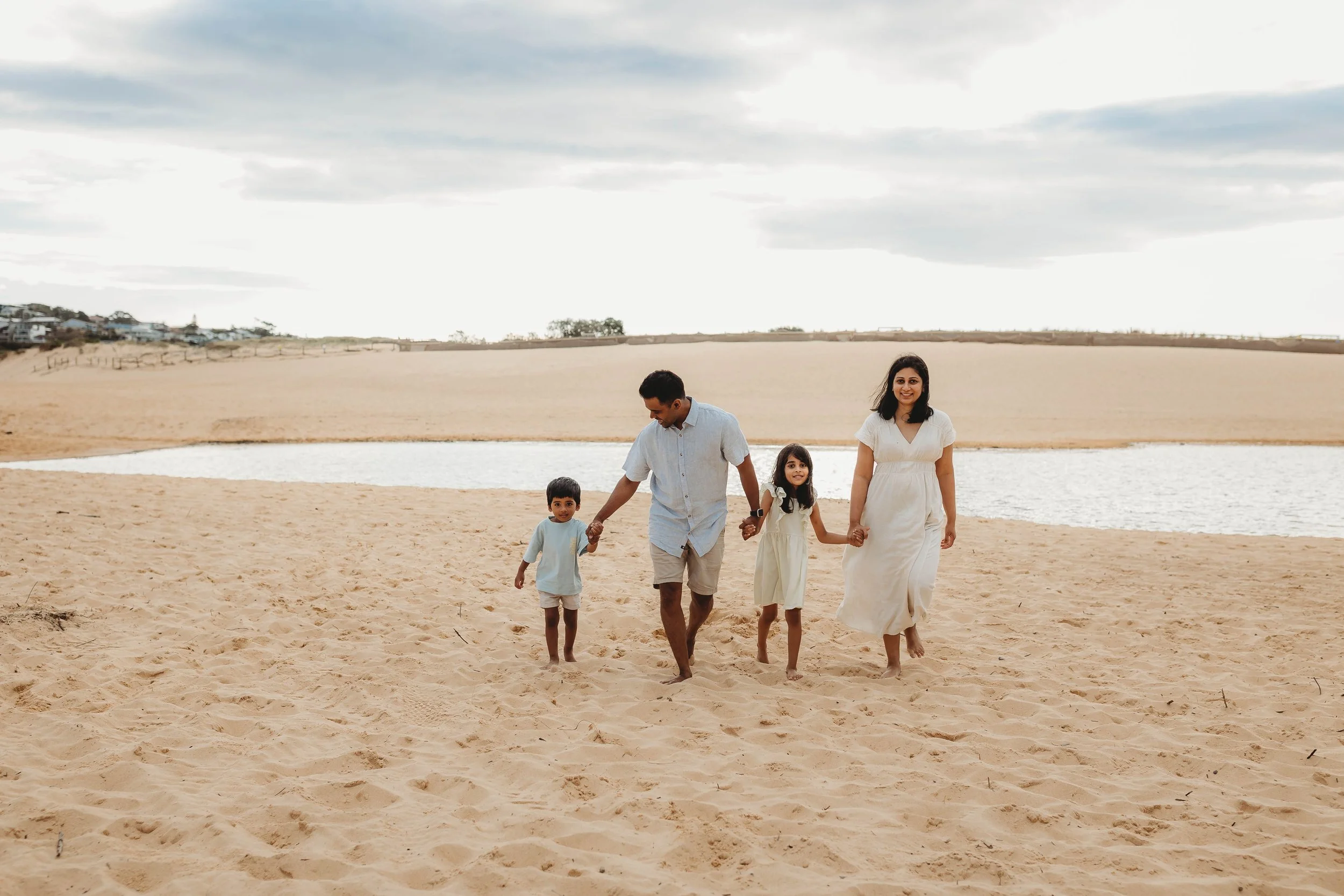 Family of 4 including a boy and girl walking on the beach at North Curl Curl
