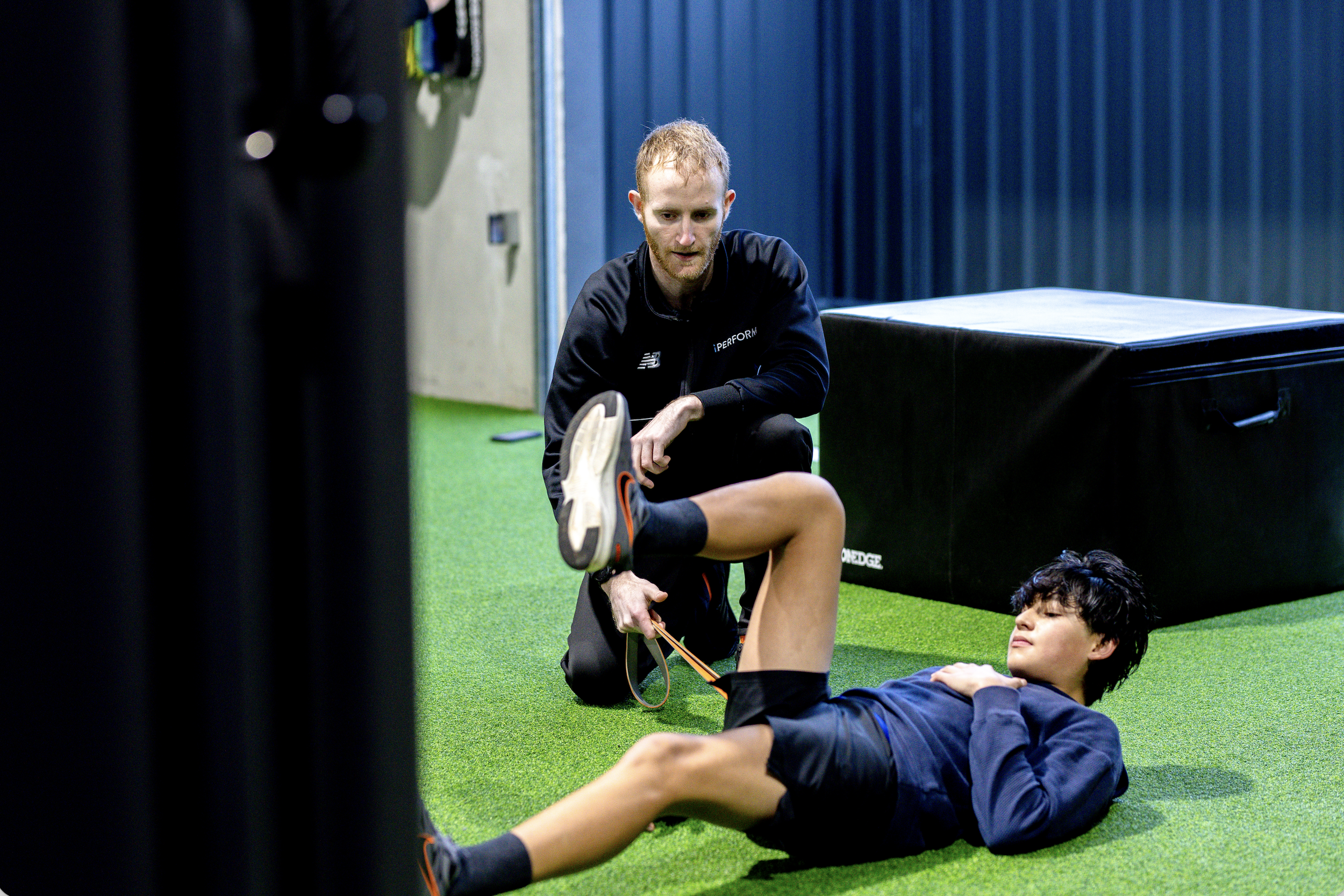 youth athlete with S&C coach completing deadbug exercise