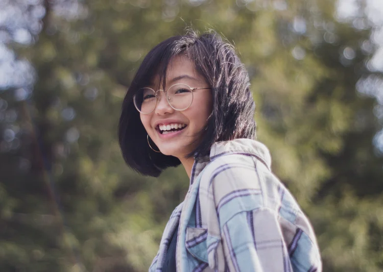 Woman in Los Angeles wearing stripes, black hair, and glasses walking after holistic therapy.