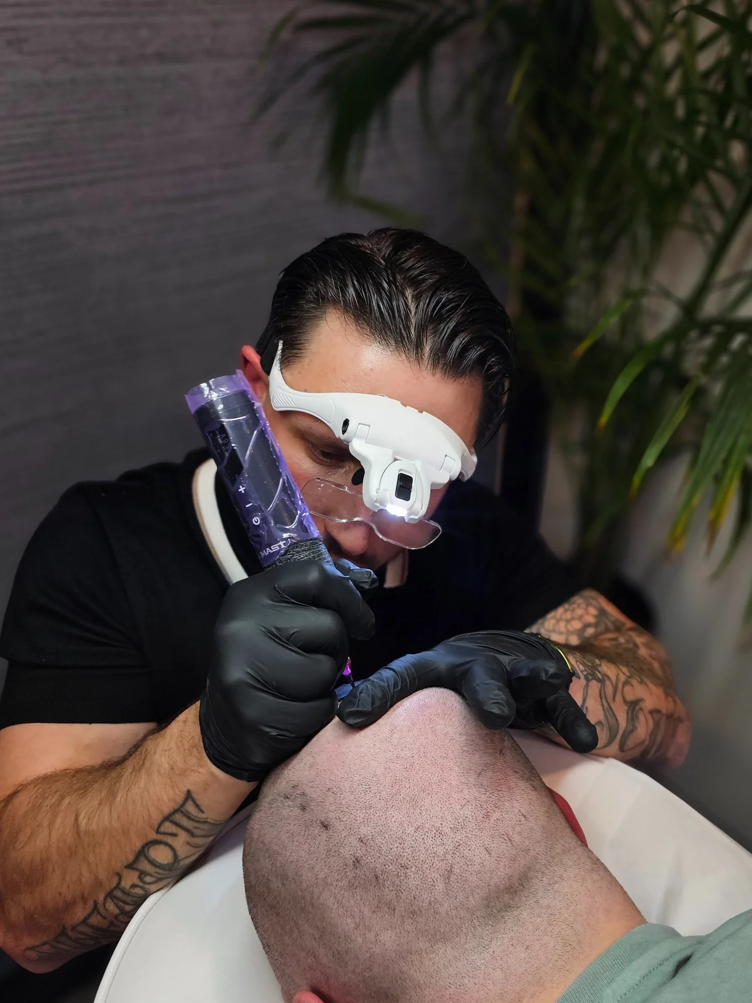 A practitioner carrying out scalp micropigmentation on a client