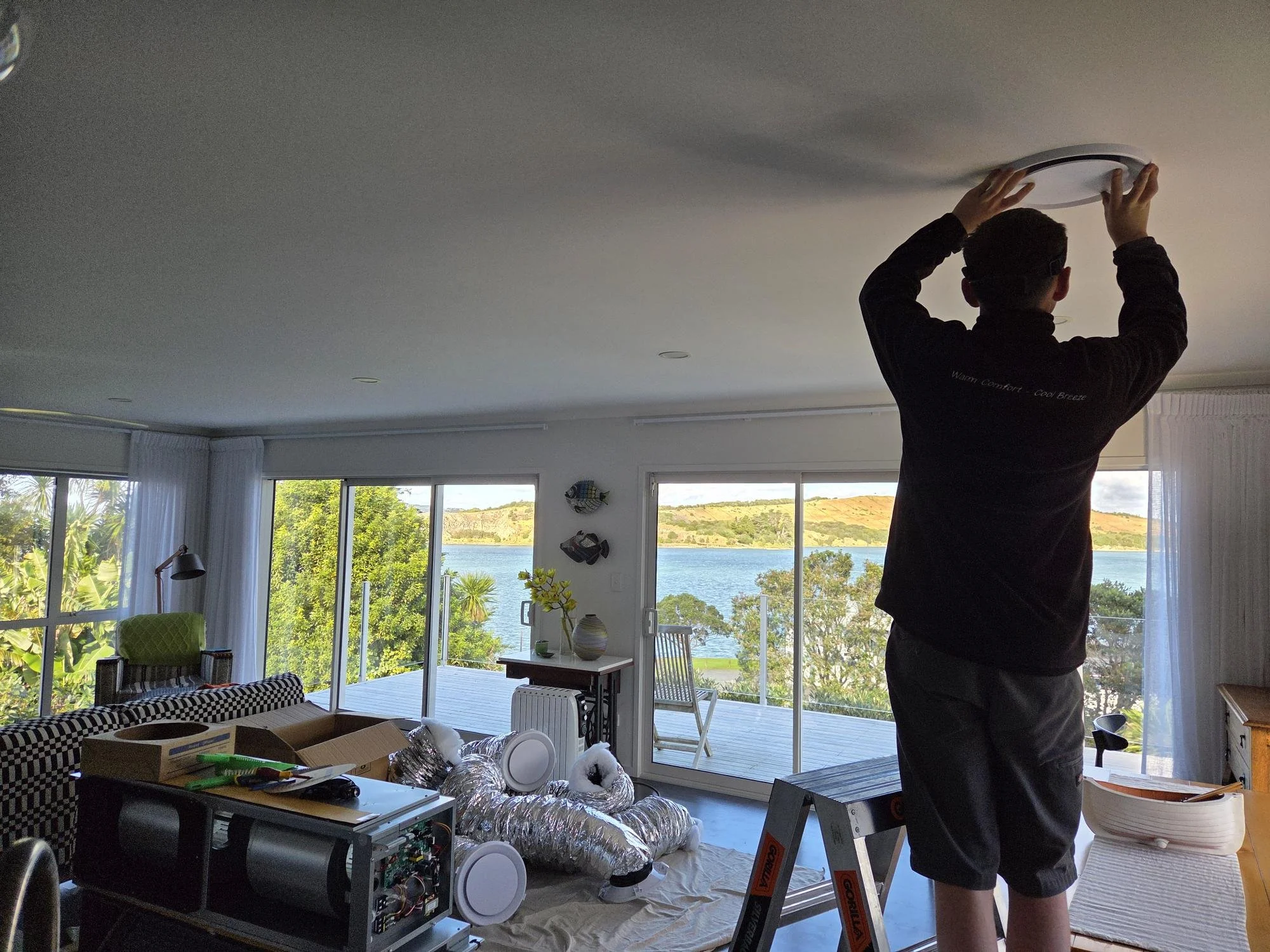 Breeze Northland HVAC technician installing a residential ducted air conditioning system in a Northland home