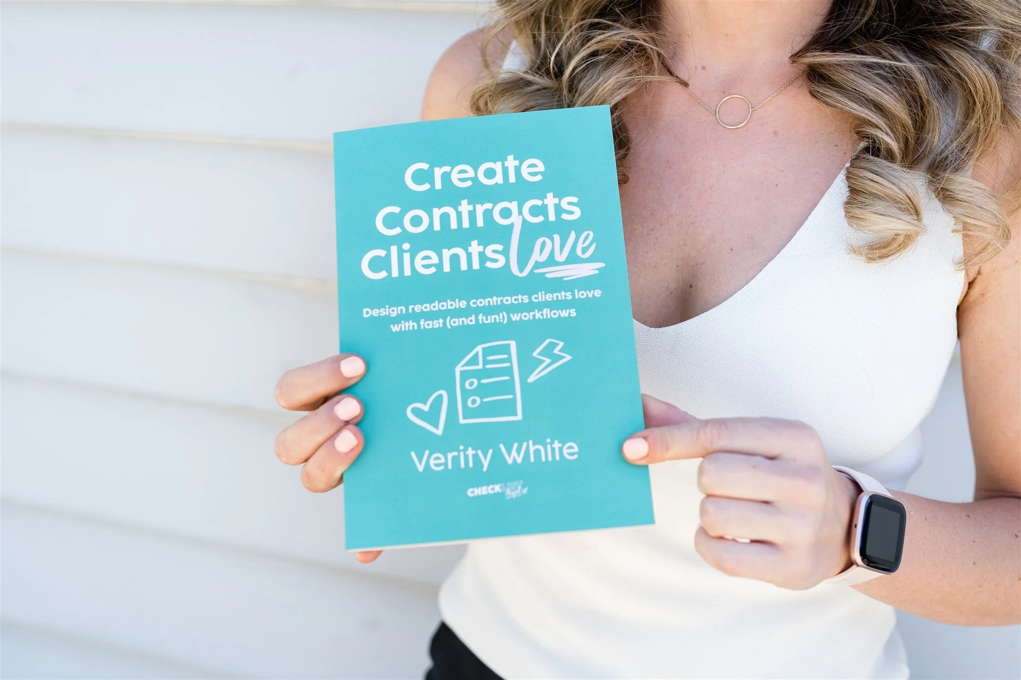Person holding Create Contracts Clients Love book by Verity White