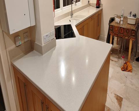 Flawless high-gloss finish on a restored Corian breakfast bar showing a crystal-clear reflection of ceiling lights.