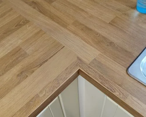 The wood effect laminate worktop water damage has been completly restored to factory finish