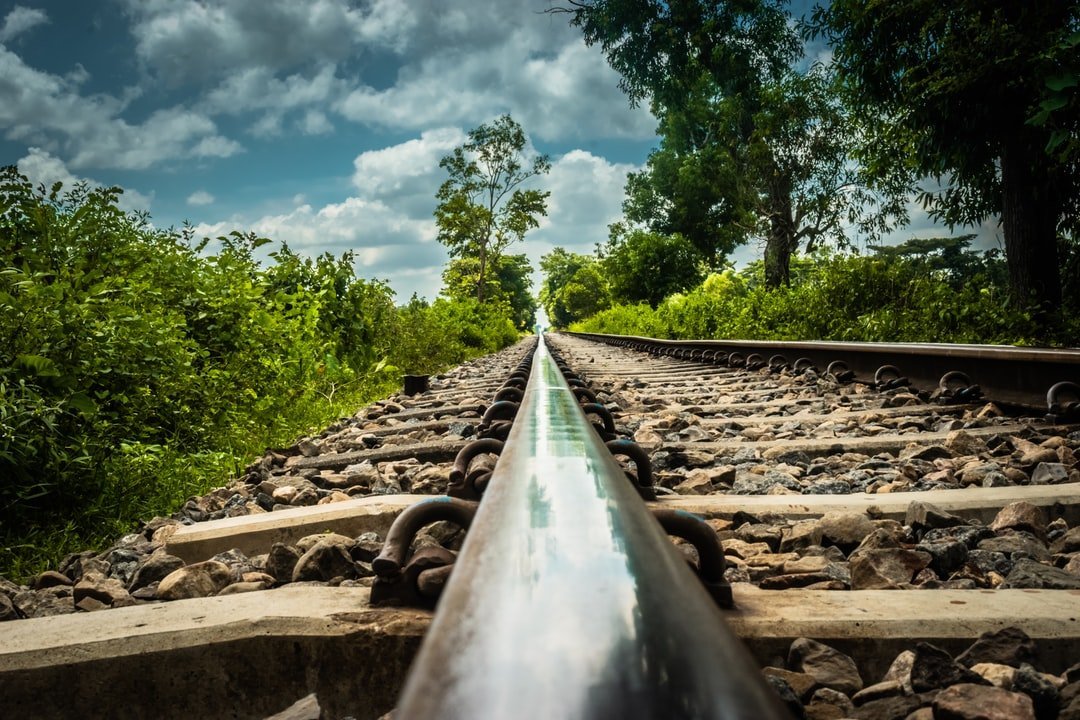 A close up of a railroad track in a green area