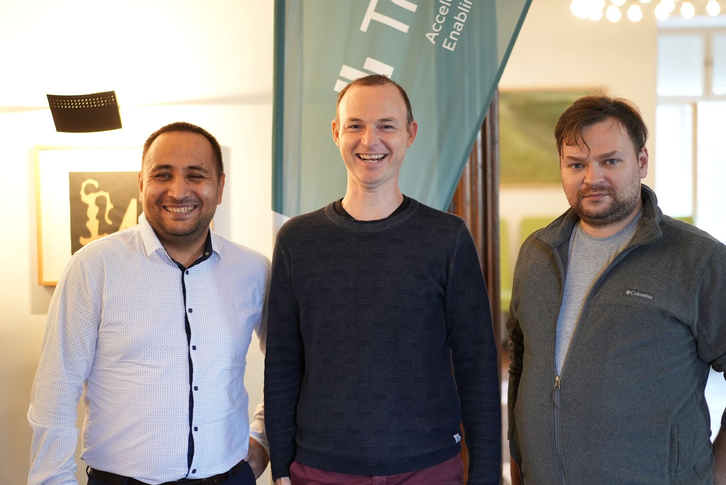 Trustbit CEO Jörg smiling at the camera with Aigiz and Sergey