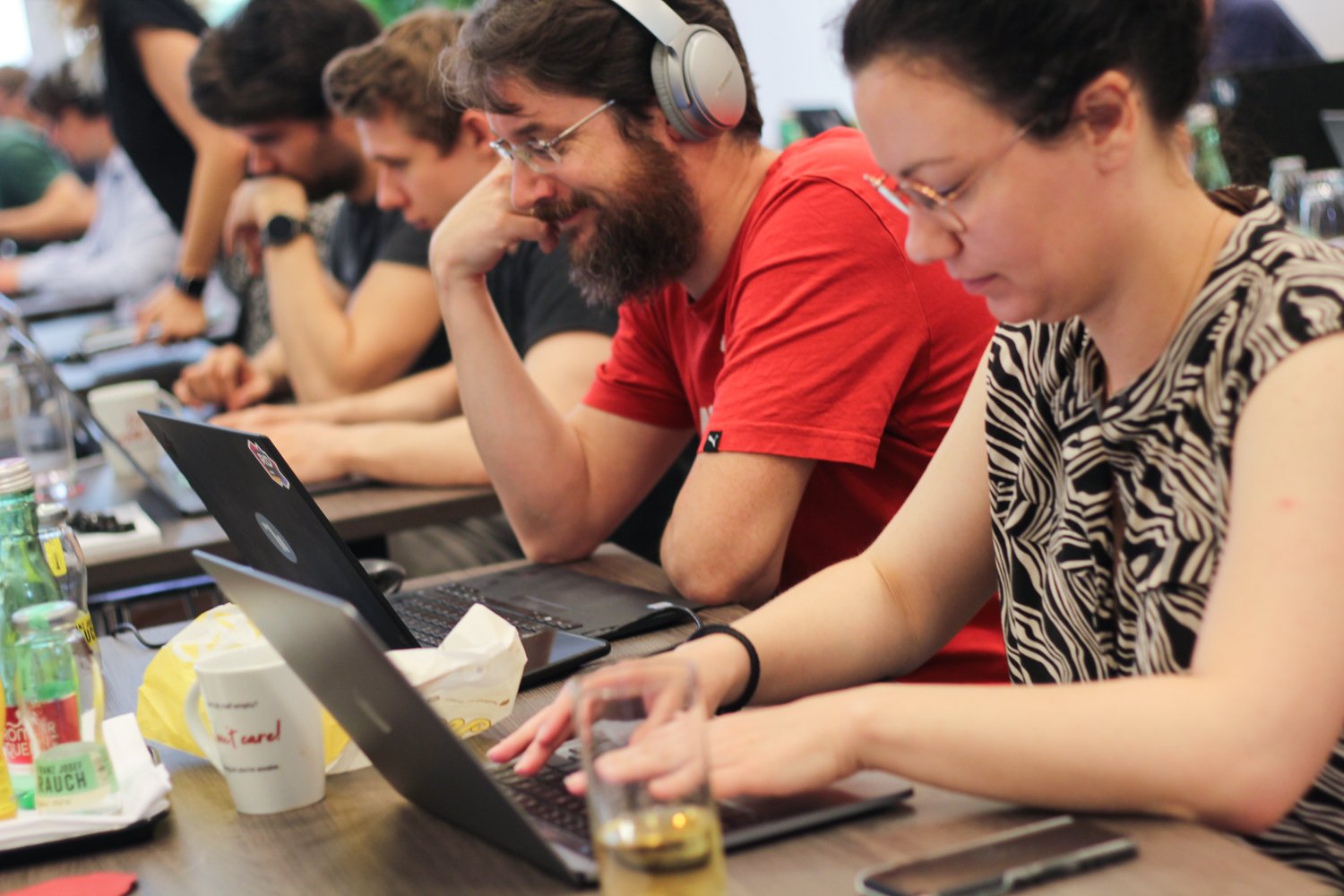 Nina, Balazs, and other employees sitting in a row at their laptops, hacking away during the LKWW Hackathon