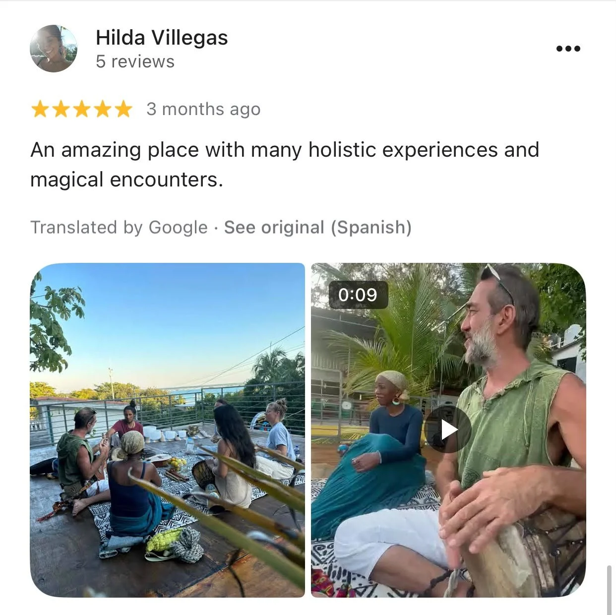 Group of people sitting around a table outdoors having a discussion or meal, with lush trees and clear sky in the background, in a tropical or warm climate setting. Review is for five stars for the magical experience.