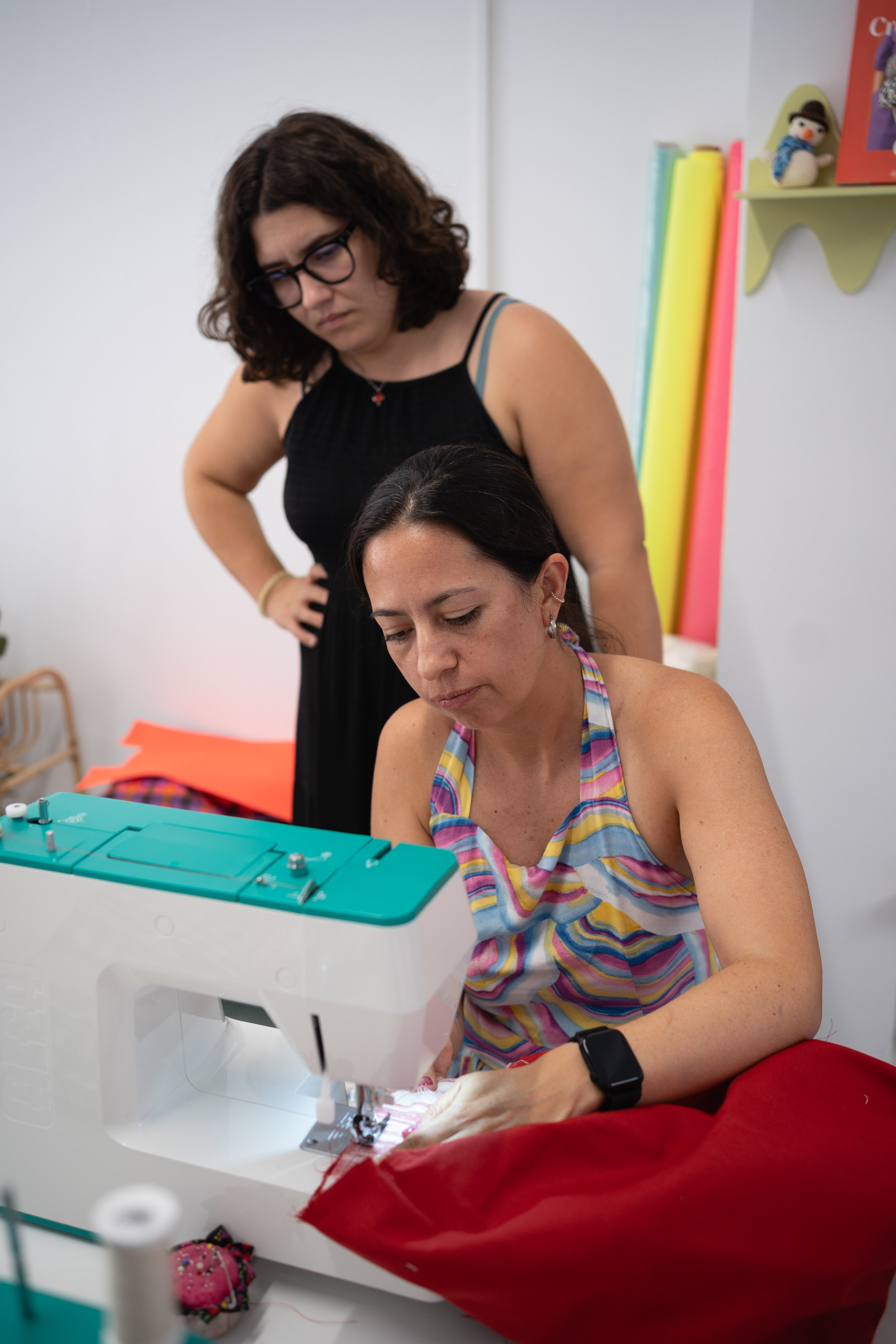 profesora enseñando a alumna maquina de coser en clases echo