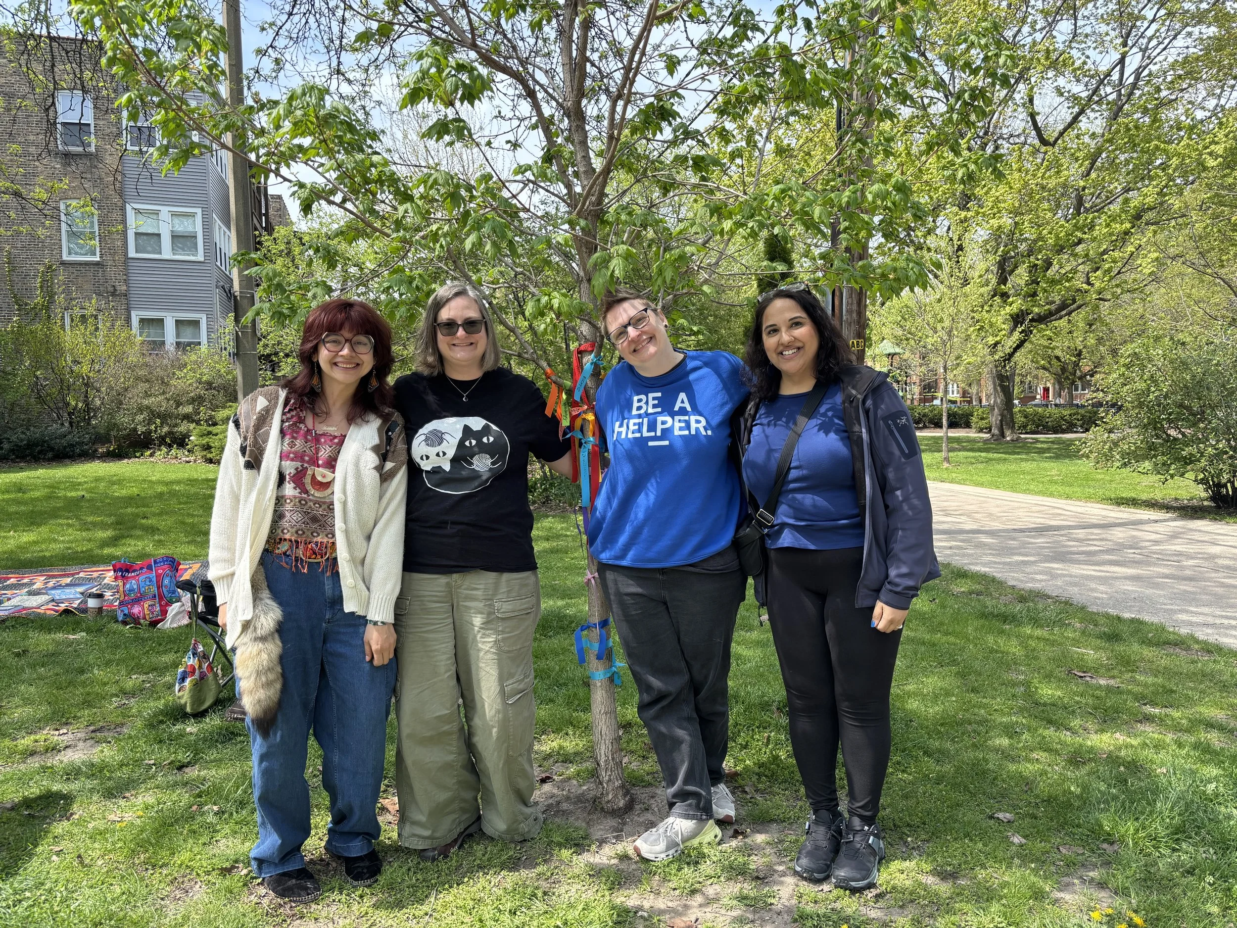 4 people standing by a tree