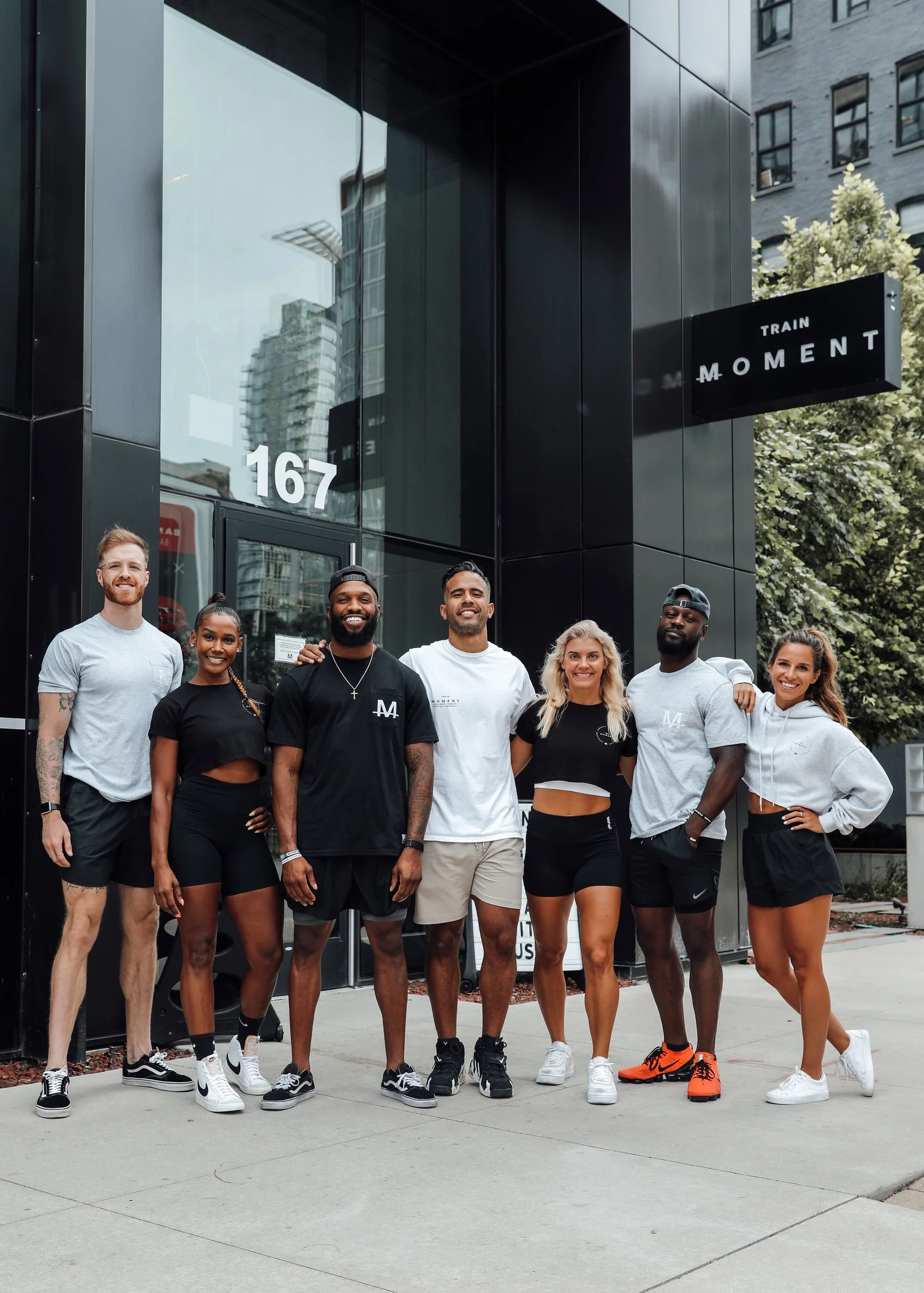 The TRAIN Moment team standing together on the sidewalk outside the studio entrance