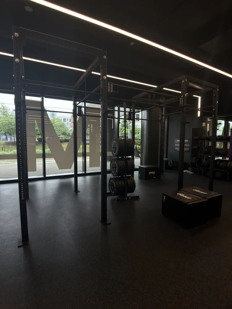 The rig and weight plates on the training floor, the M mark on the window glass behind