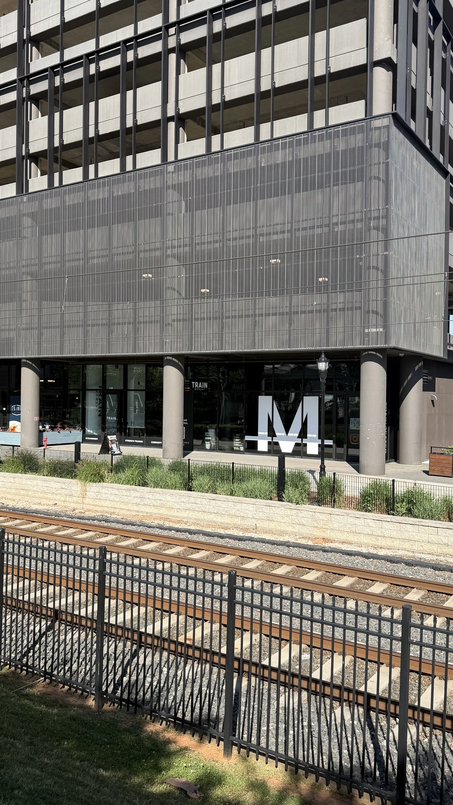 The studio from across the light rail tracks, the M mark on the ground floor of the building