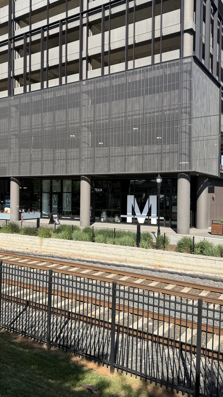 The studio from across the light rail tracks, the M mark on the ground floor of the building