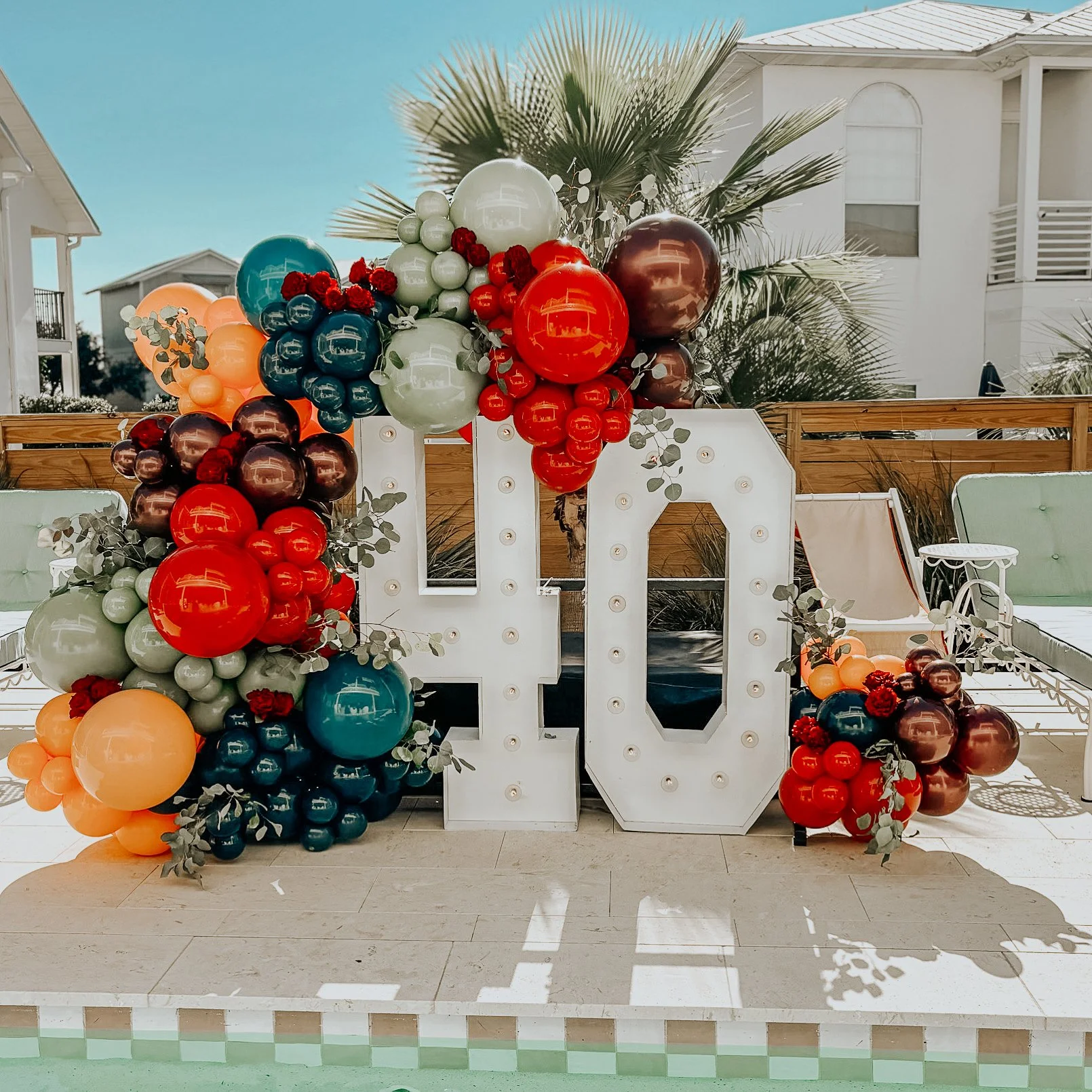 Luxury 40th birthday balloon installation at a private vacation home in Alys Beach, Florida featuring custom number marquee lights and organic balloon décor.