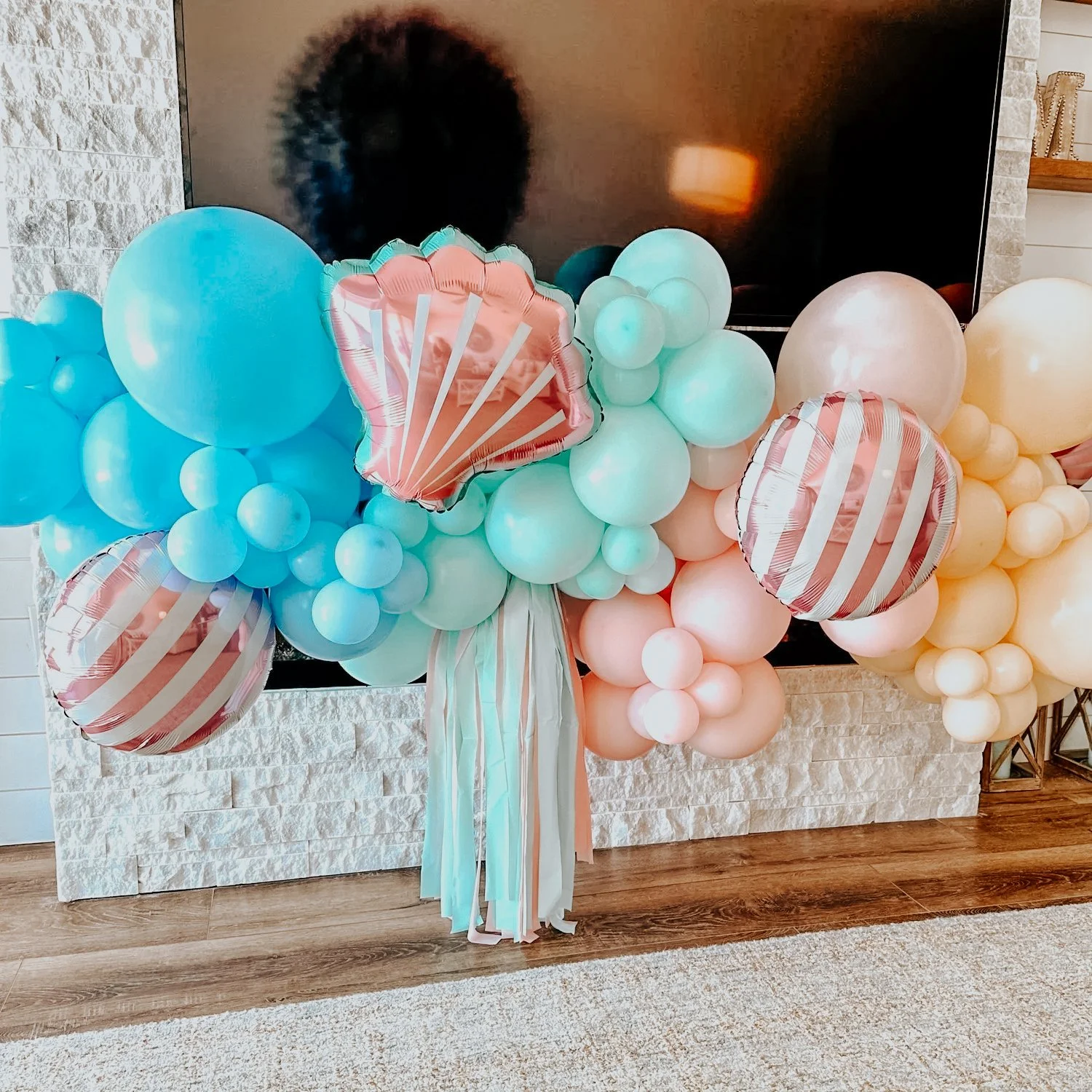 Sea-themed balloon arrangement with pastel blue, pink, yellow, and green balloons plus metallic shell accents and ribbons styled for a 30A birthday, bridal, bachelorette, or baby shower celebration.