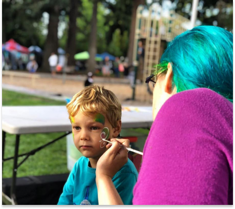 Kid getting their face painted at Art in the Park Event.