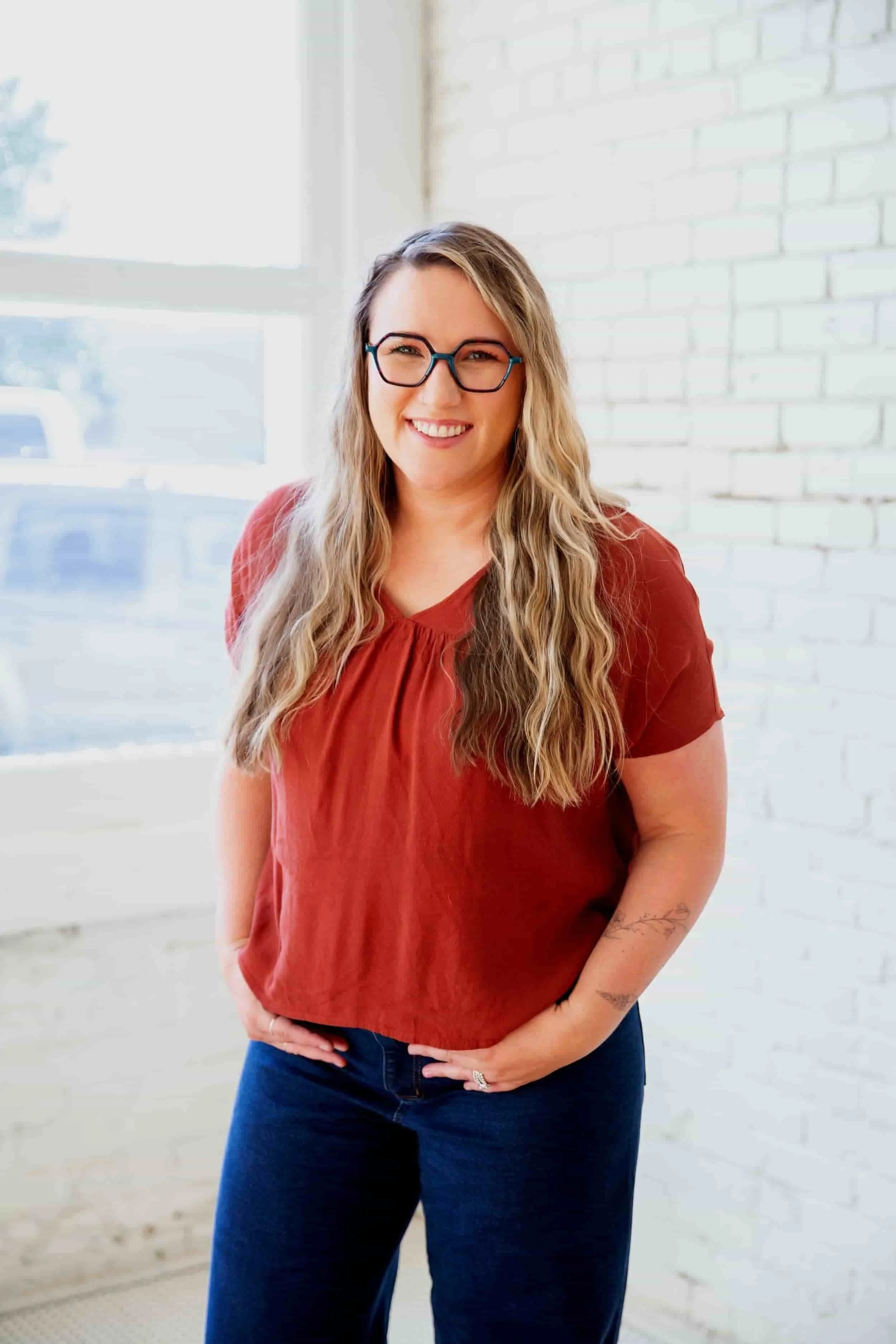Sarah Robinson smiles at the camera, her arms folded one on top of the other