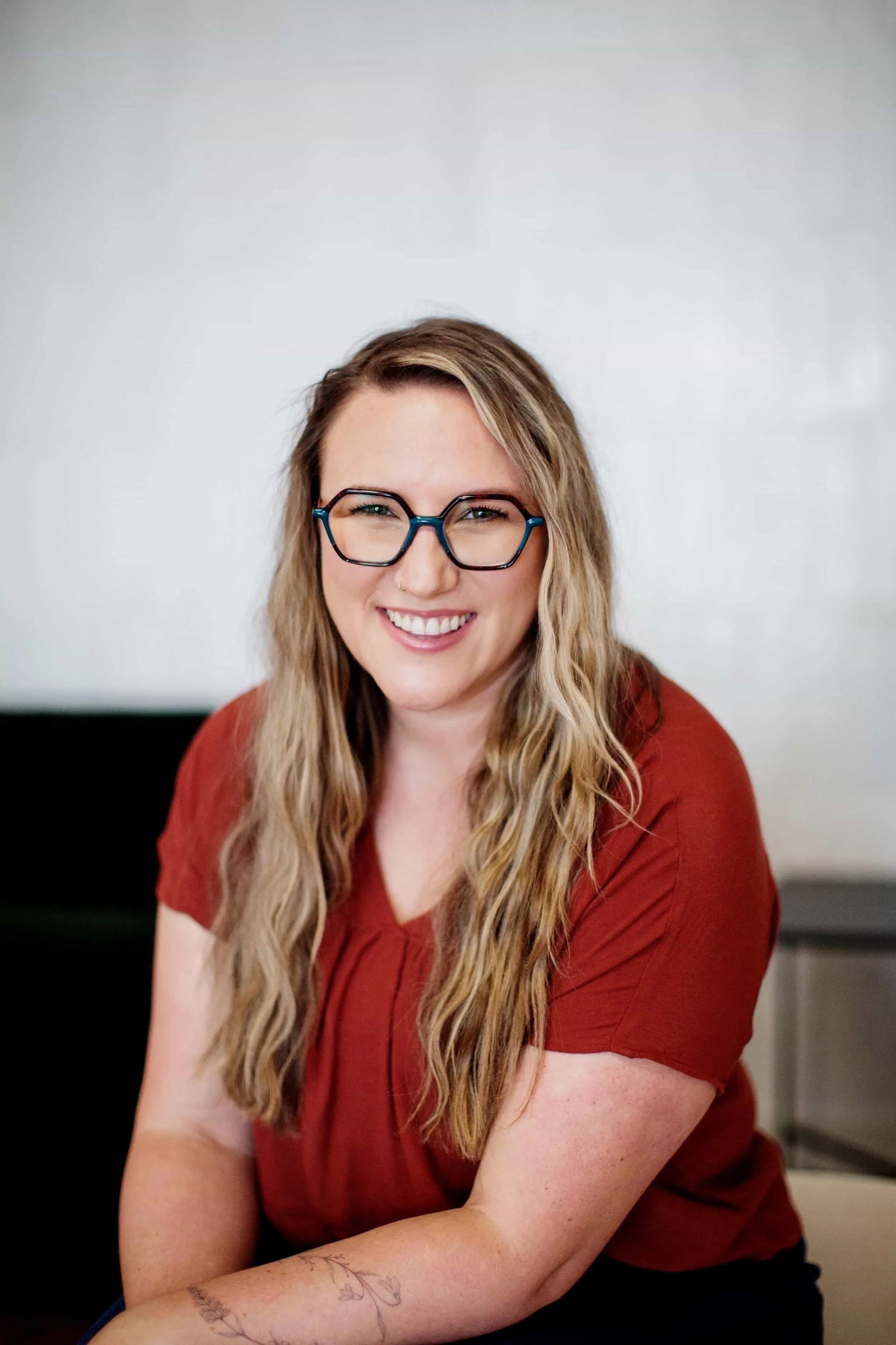 Sarah Robinson smiles at the camera, her arms folded one on top of the other