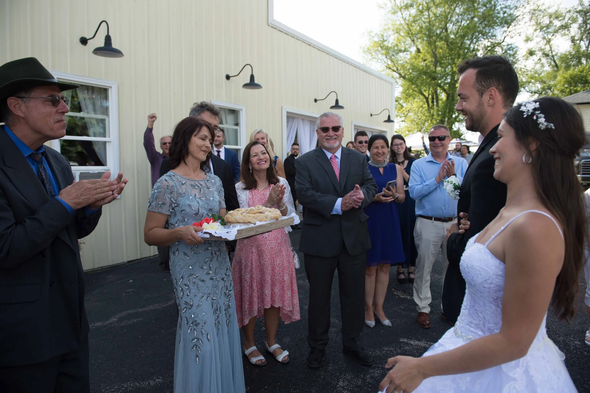 Bride and groom receiving a traditional loaf of bread and salt from the bride’s parents during a Polish wedding blessing at Country Coach House in Illinois.
