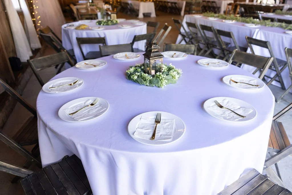 The round table with a lantern and greenery as the centerpiece at Country Coach House in Burlington, IL 