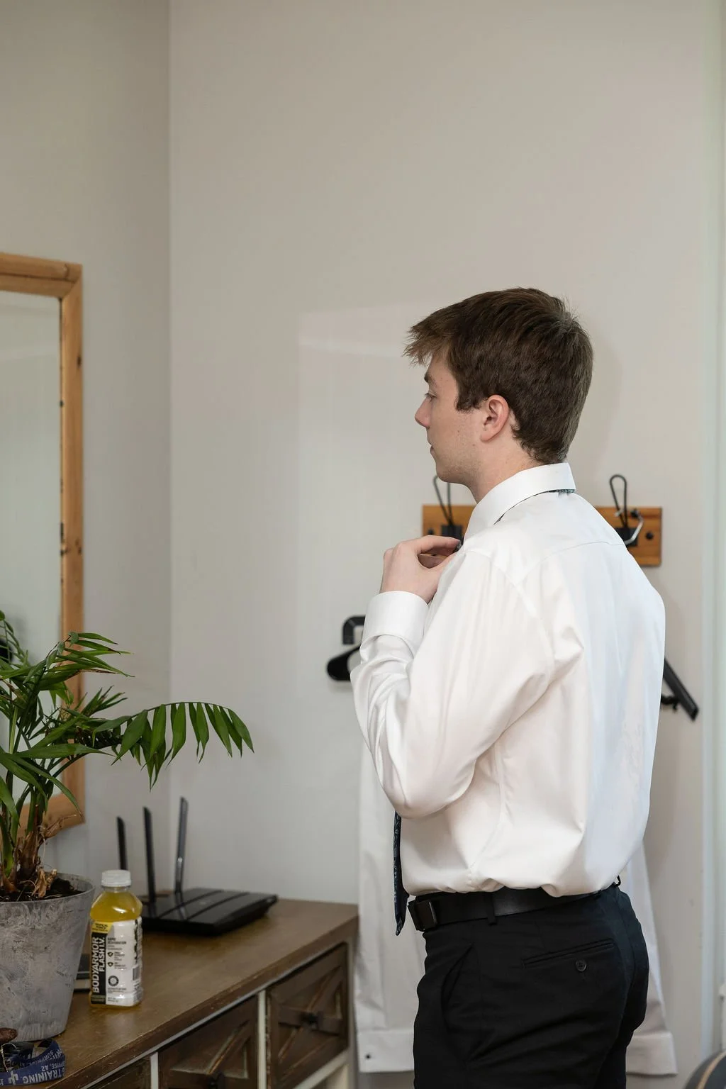 The groom adjusting his tie at Country Coach House wedding venue in Burlington, IL 