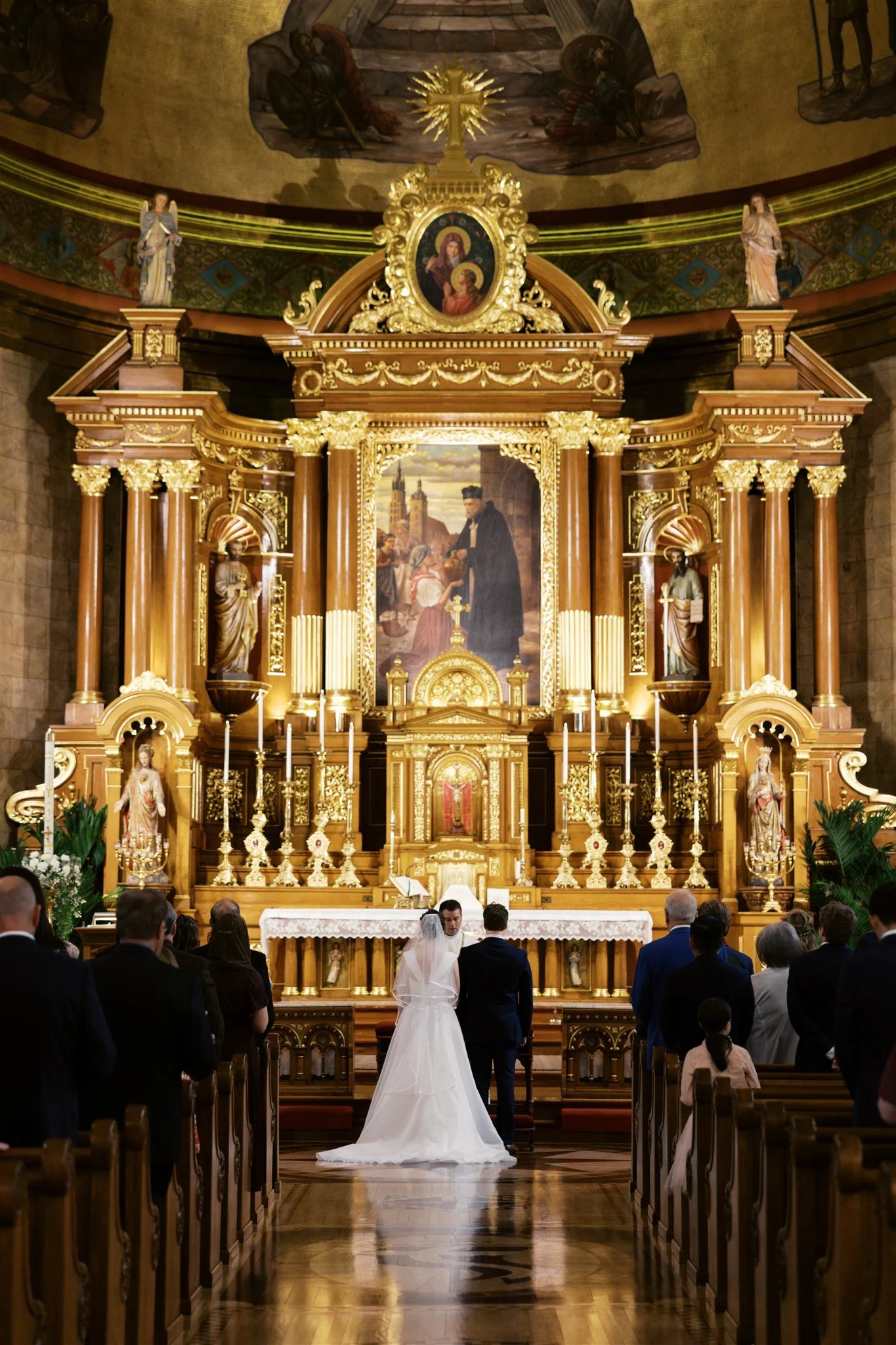 The bride and groom at the altar at St.John Cancius Catholic Church in Chicago, before their wedding reception at Country Coach House in Burlington, IL 