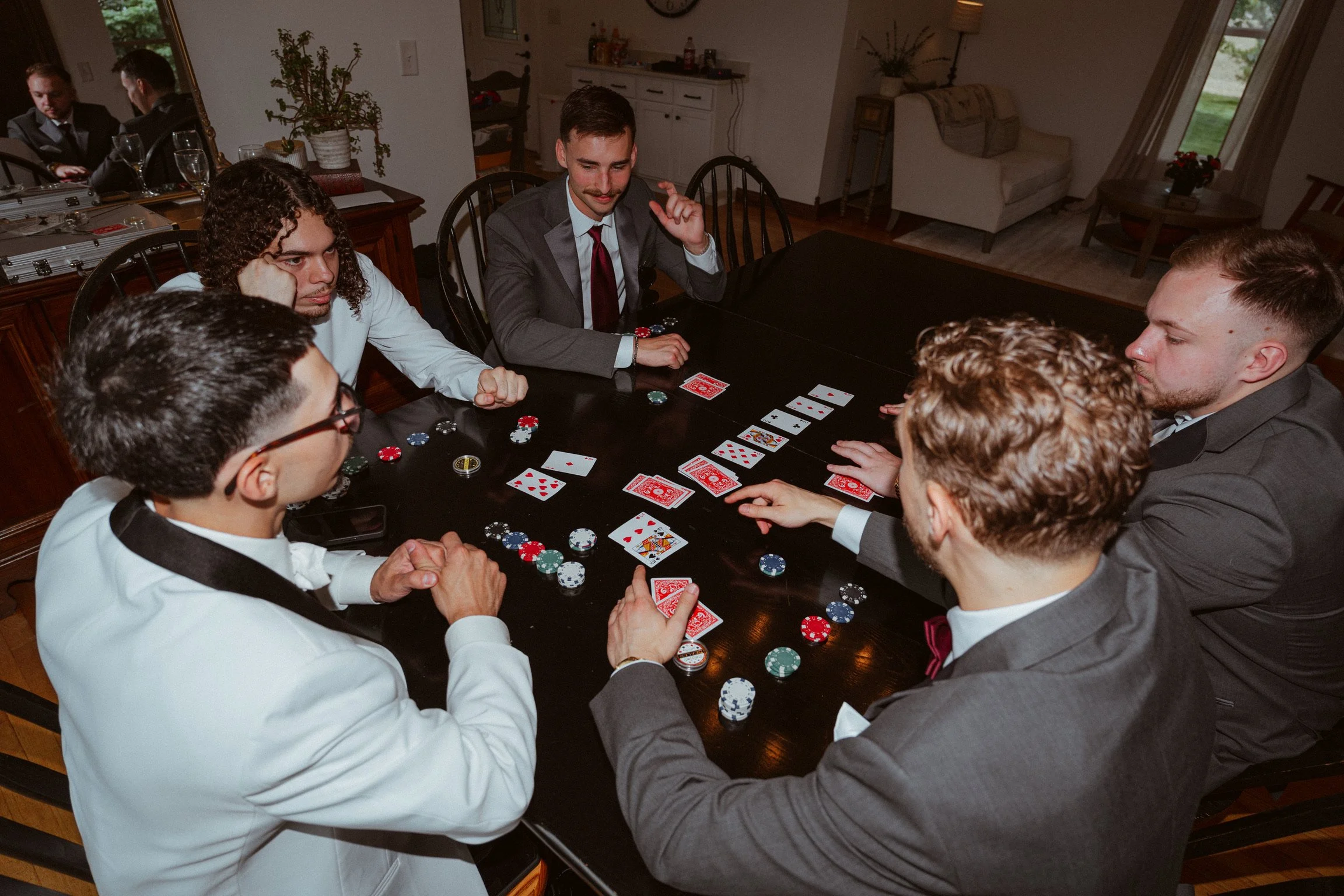 The groom and his groomsmen in the farmhouse, playing poker, after getting dressed for the wedding at Country Coach House in Burlington, IL.