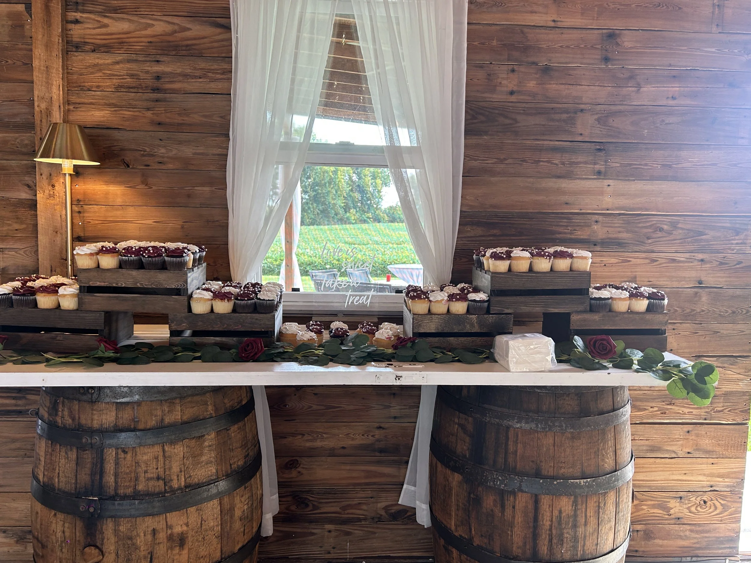 A dessert display on a door with two barrels. Country Coach House Photo