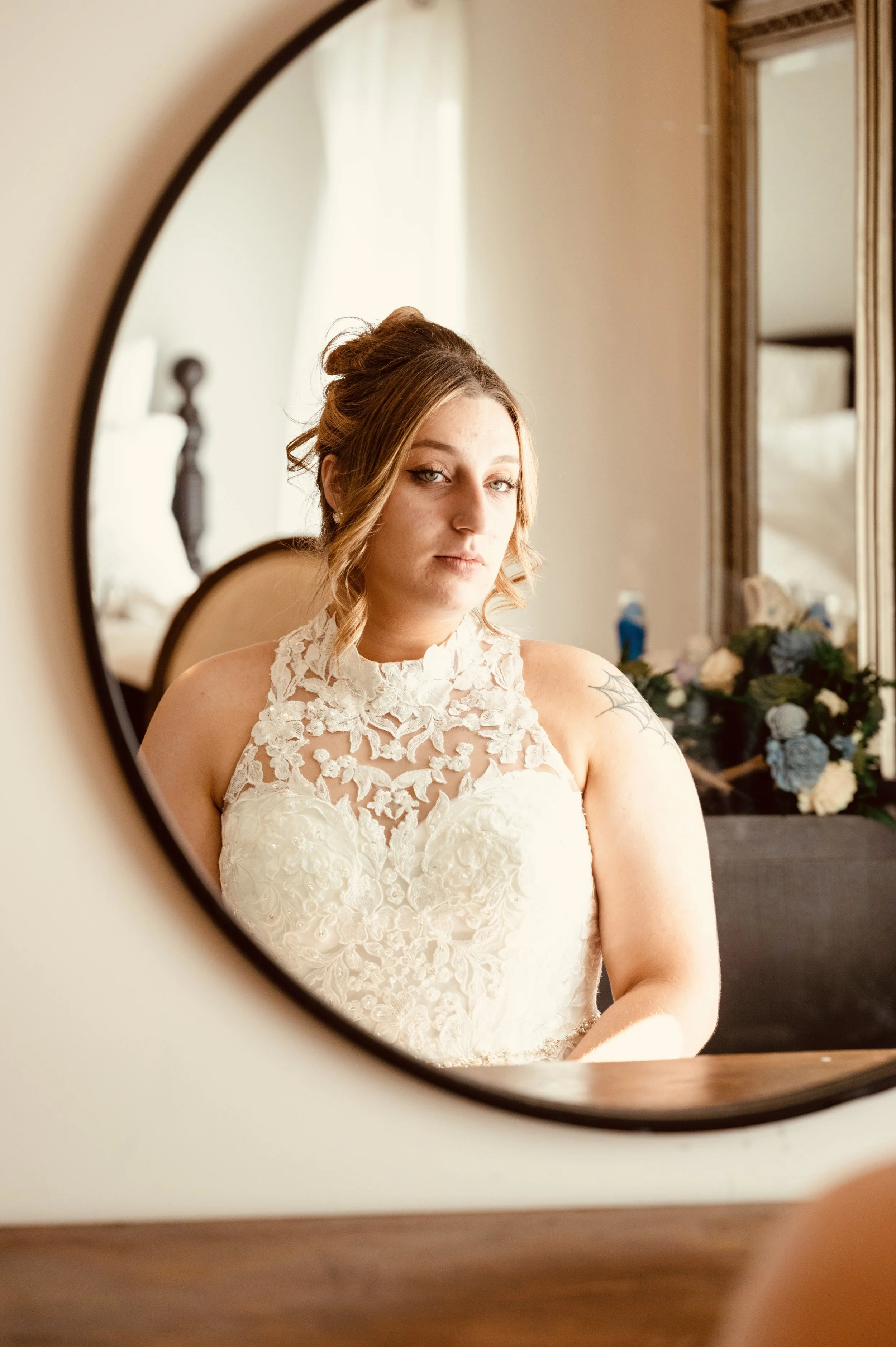 Bride looking in a mirror before her wedding ceremony at Country Coach House.