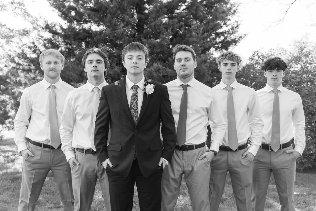 The groom and his groomsmen are outside on the property at Country Coach House wedding venue in Burlington, IL 