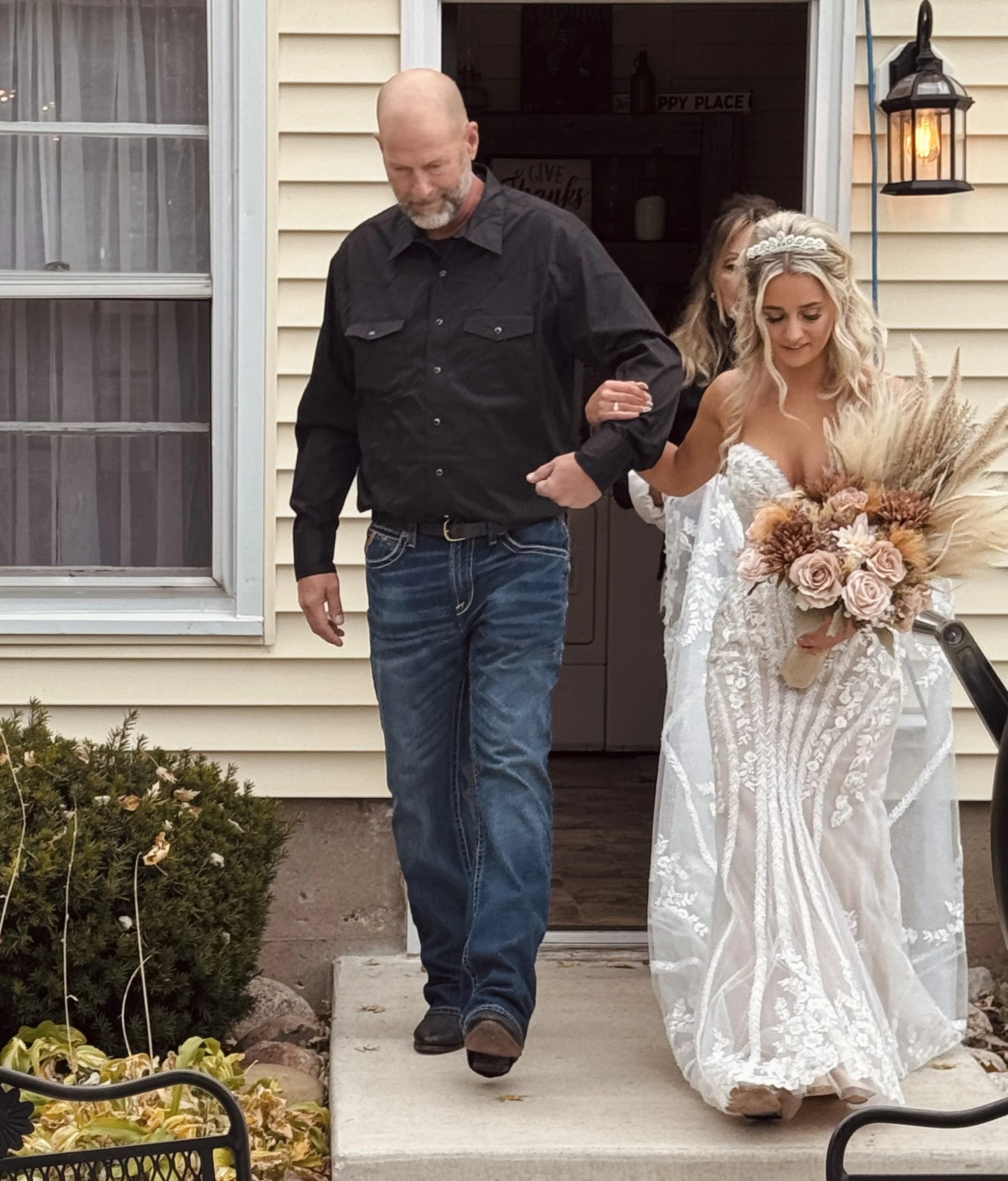 The bride steps out of the house on her father’s arm, beginning her walk down the aisle at Country Coach House. Photo by Country Coach House.