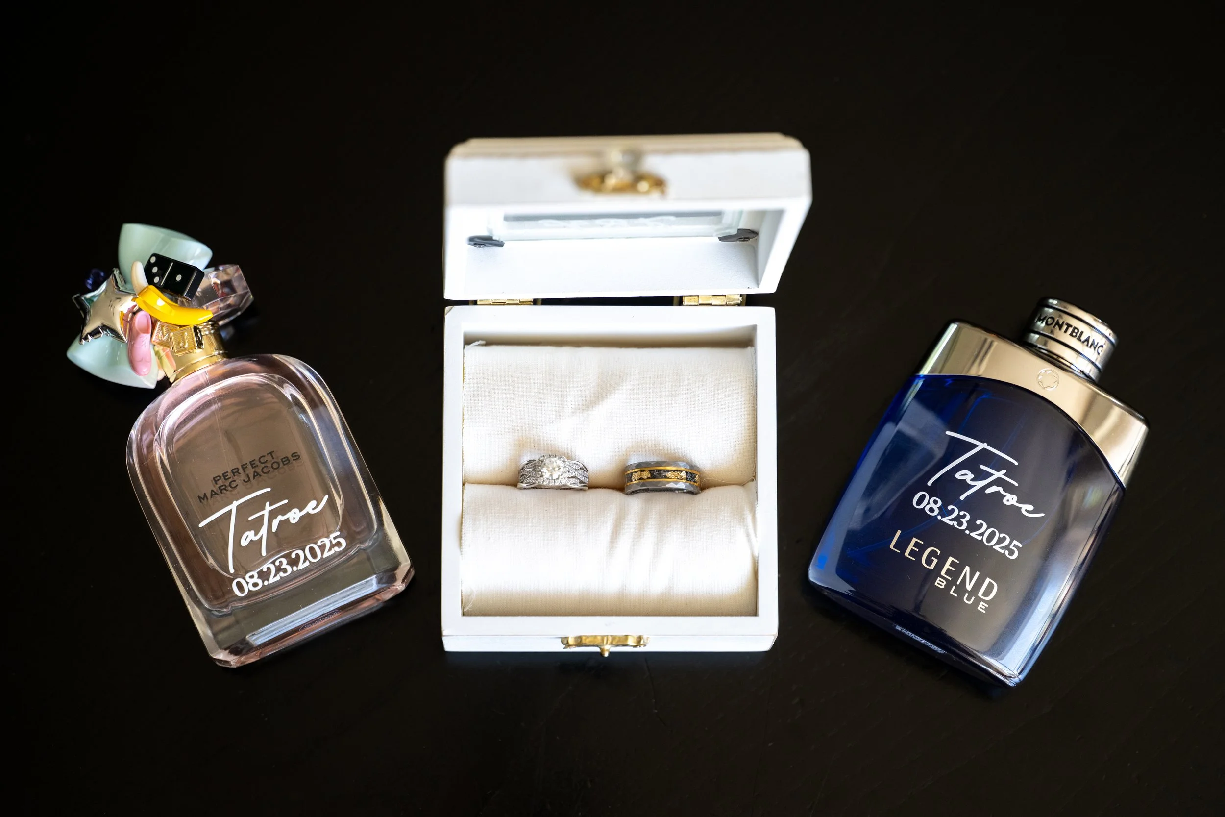Lindsey and Alex’s wedding rings, symbols of their love and commitment, alongside both of their colognes — keepsakes that bring back the memories of their special day at Country Coach House.