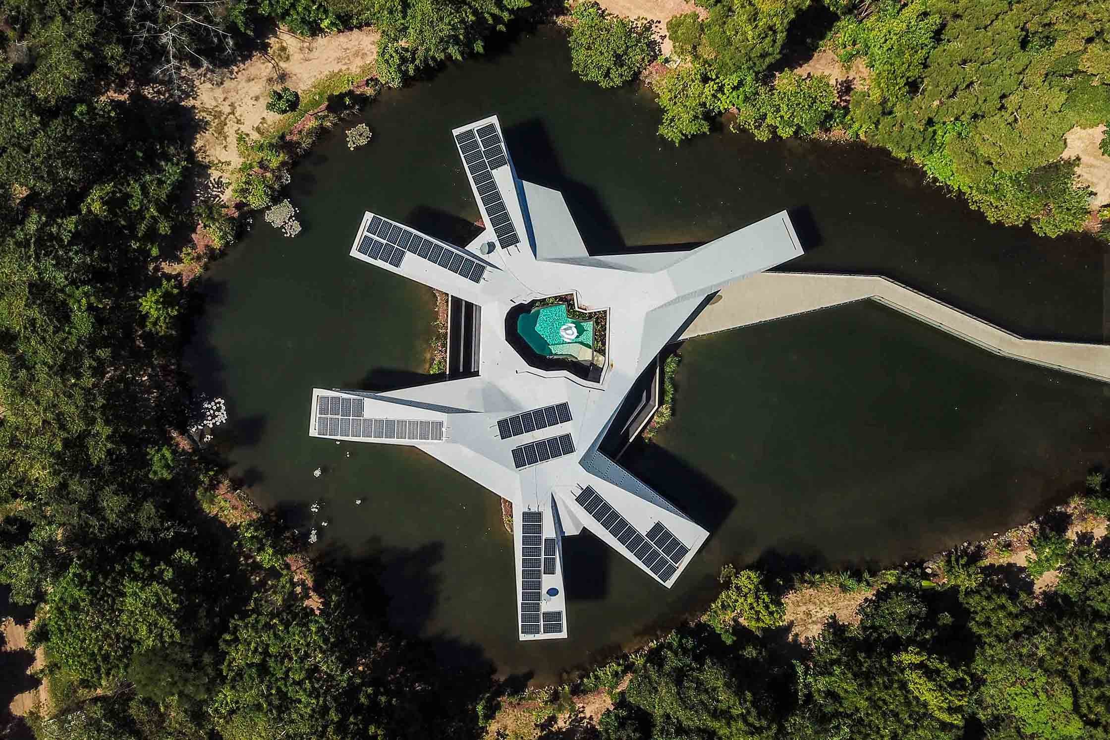 A birdseye view of Alkira Resort House showing the pool, lake, garden, and eco-friendly solar panels