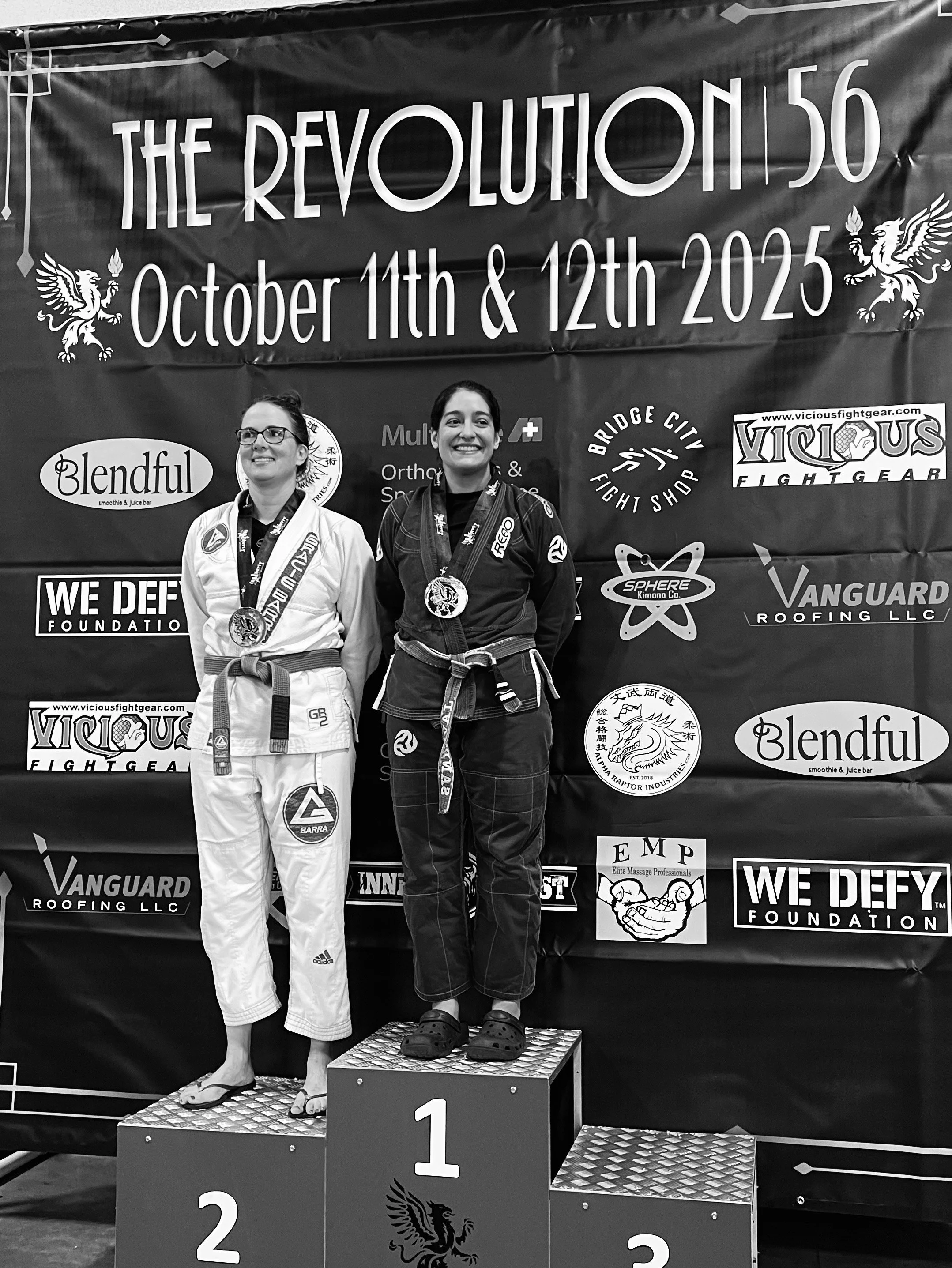 Women's jiu jitsu team member on podium after winning adult purple belt gi BJJ bracket at Revolution 56 tournament in Seattle, WA