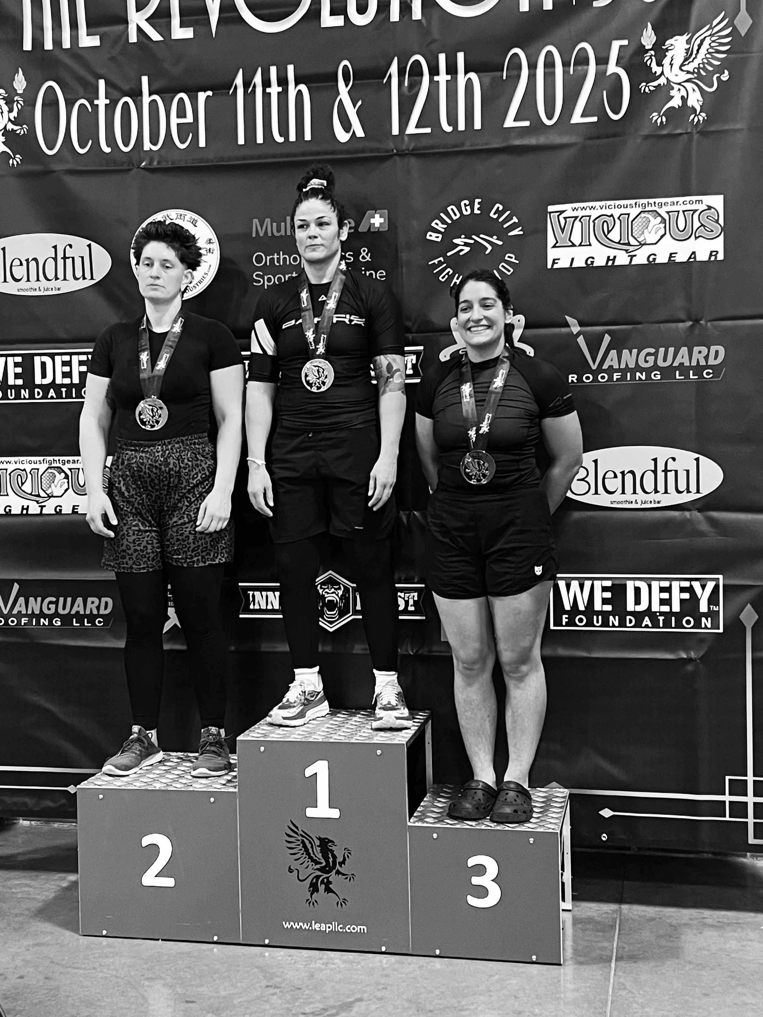 OGA female BJJ team member on podium after placing third at Revolution 56 tournament in Seattle, WA
