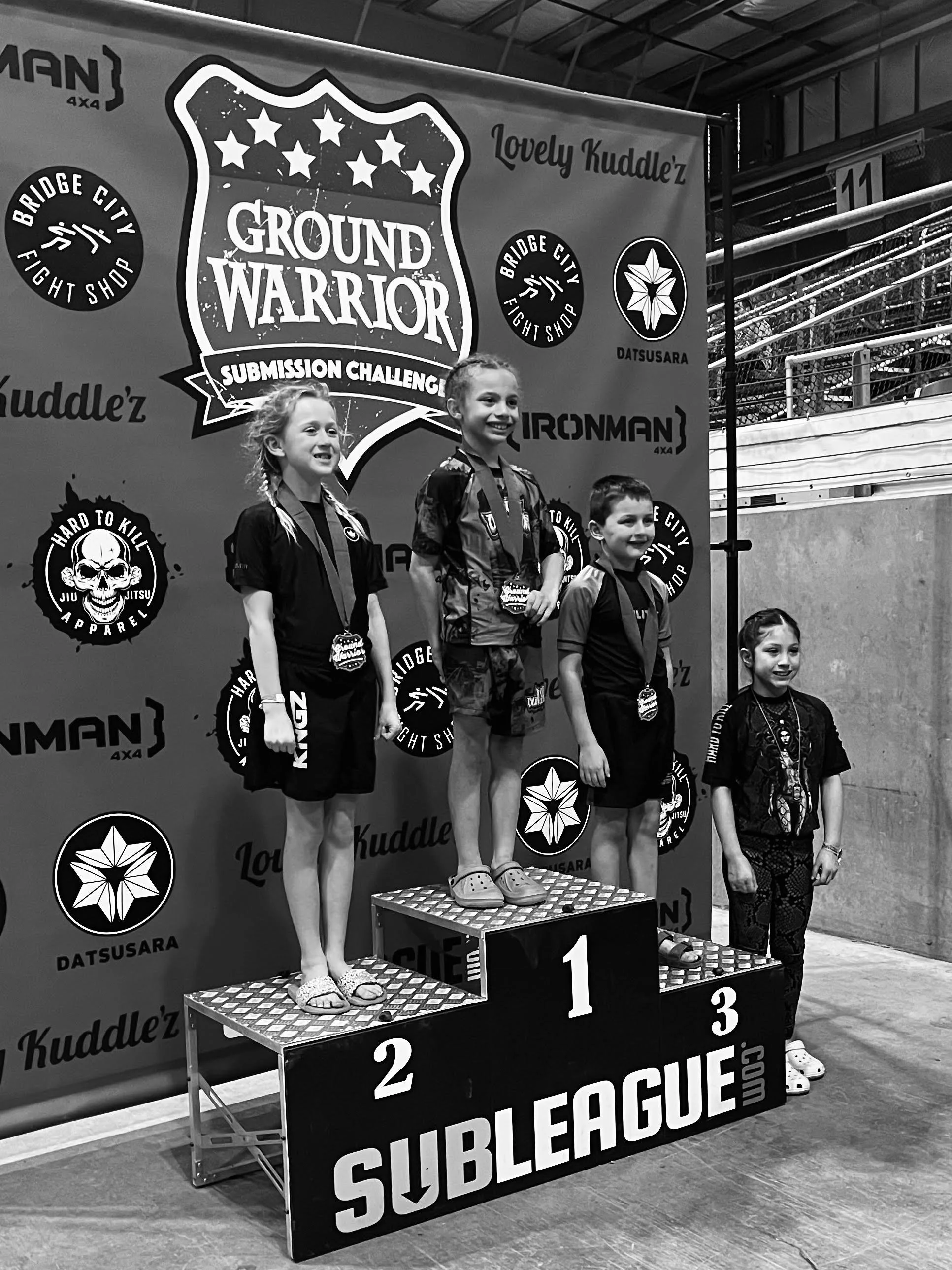 Oregon Grappling Arts kids BJJ team competitor standing atop podium after taking first place at the Ground Warrior tournament
