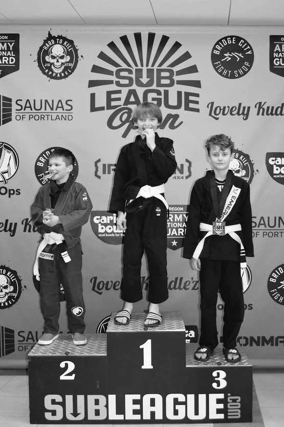 Kids nogi submission grappling and BJJ team members placing first and second in their gi division at the 2026 Sub League Open